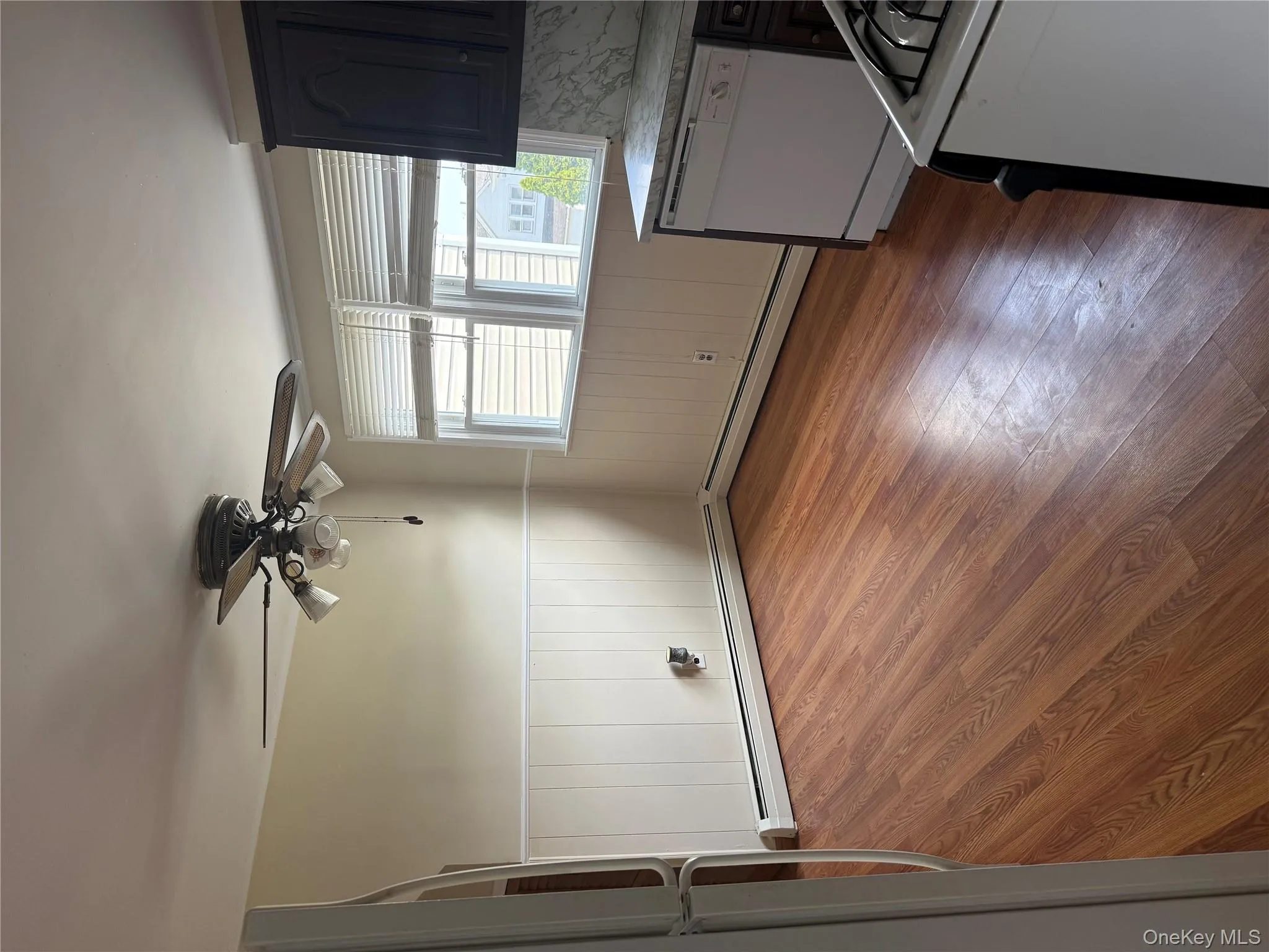 Unfurnished dining area featuring wood finished floors, ceiling fan, and wainscoting Unfurnished dining area featuring wood finished floors, ceiling fan, and wainscoting