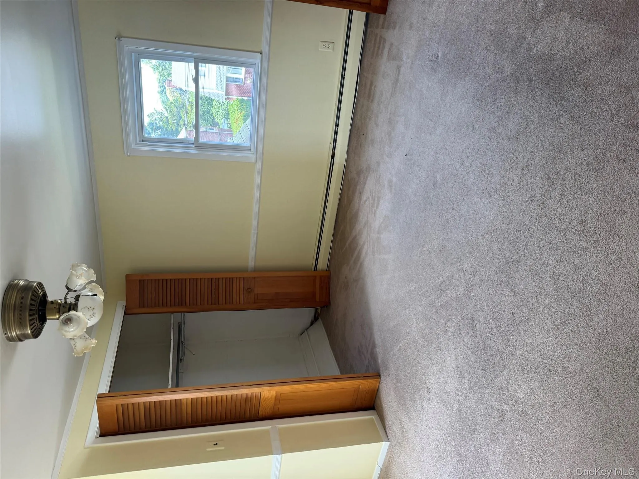 Unfurnished bedroom with carpet, baseboard heating, a closet, and ornamental molding Unfurnished bedroom with carpet, baseboard heating, a closet, and ornamental molding