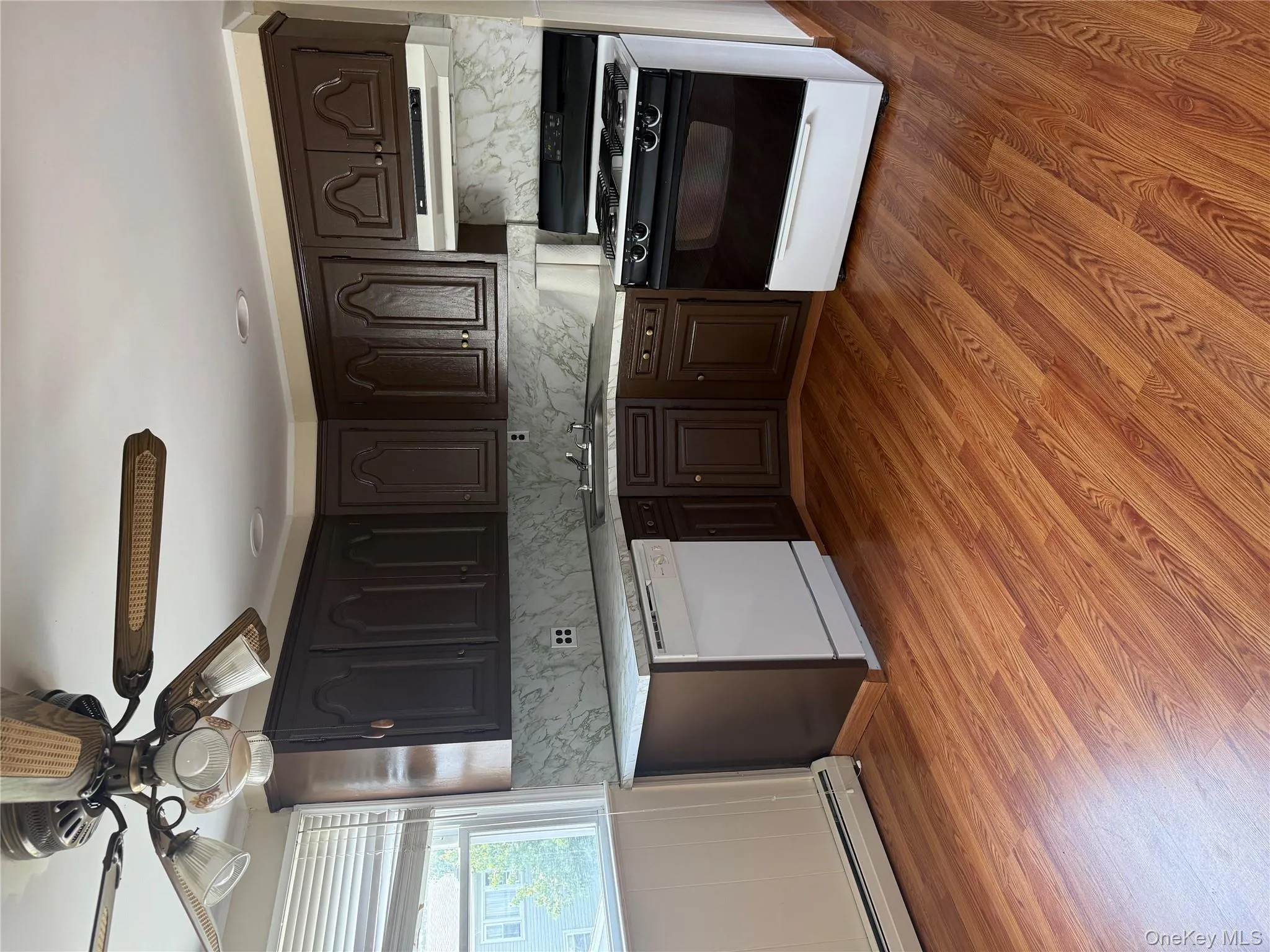 Kitchen with range, light countertops, and dark brown cabinetry Kitchen with range, light countertops, and dark brown cabinetry