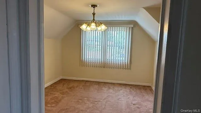 Bonus room featuring carpet flooring, a chandelier, and lofted ceiling Bonus room featuring carpet flooring, a chandelier, and lofted ceiling