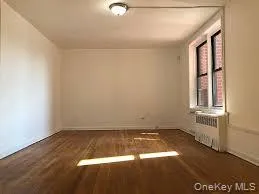 Unfurnished room with dark wood-style flooring and baseboards Unfurnished room with dark wood-style flooring and baseboards