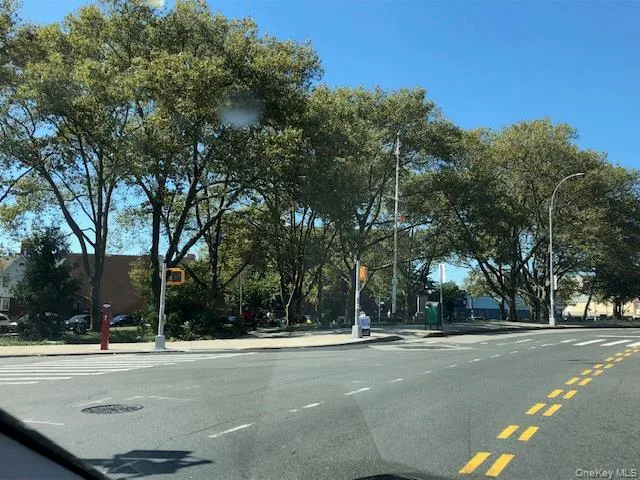 View of asphalt road featuring curbs, sidewalks, and street lighting View of asphalt road featuring curbs, sidewalks, and street lighting