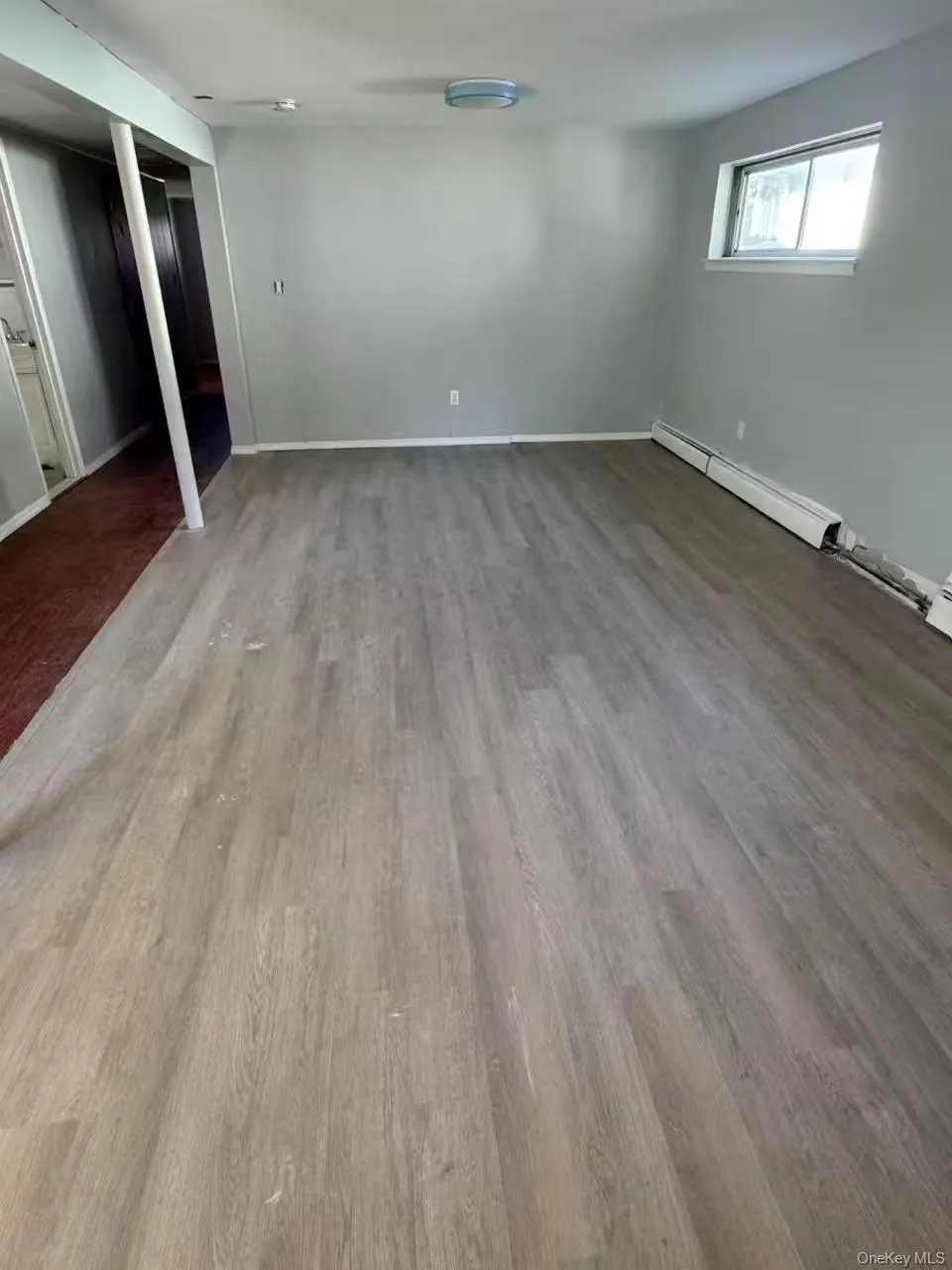 Unfurnished bedroom featuring light wood-style flooring, a baseboard radiator, and a closet Unfurnished bedroom featuring light wood-style flooring, a baseboard radiator, and a closet