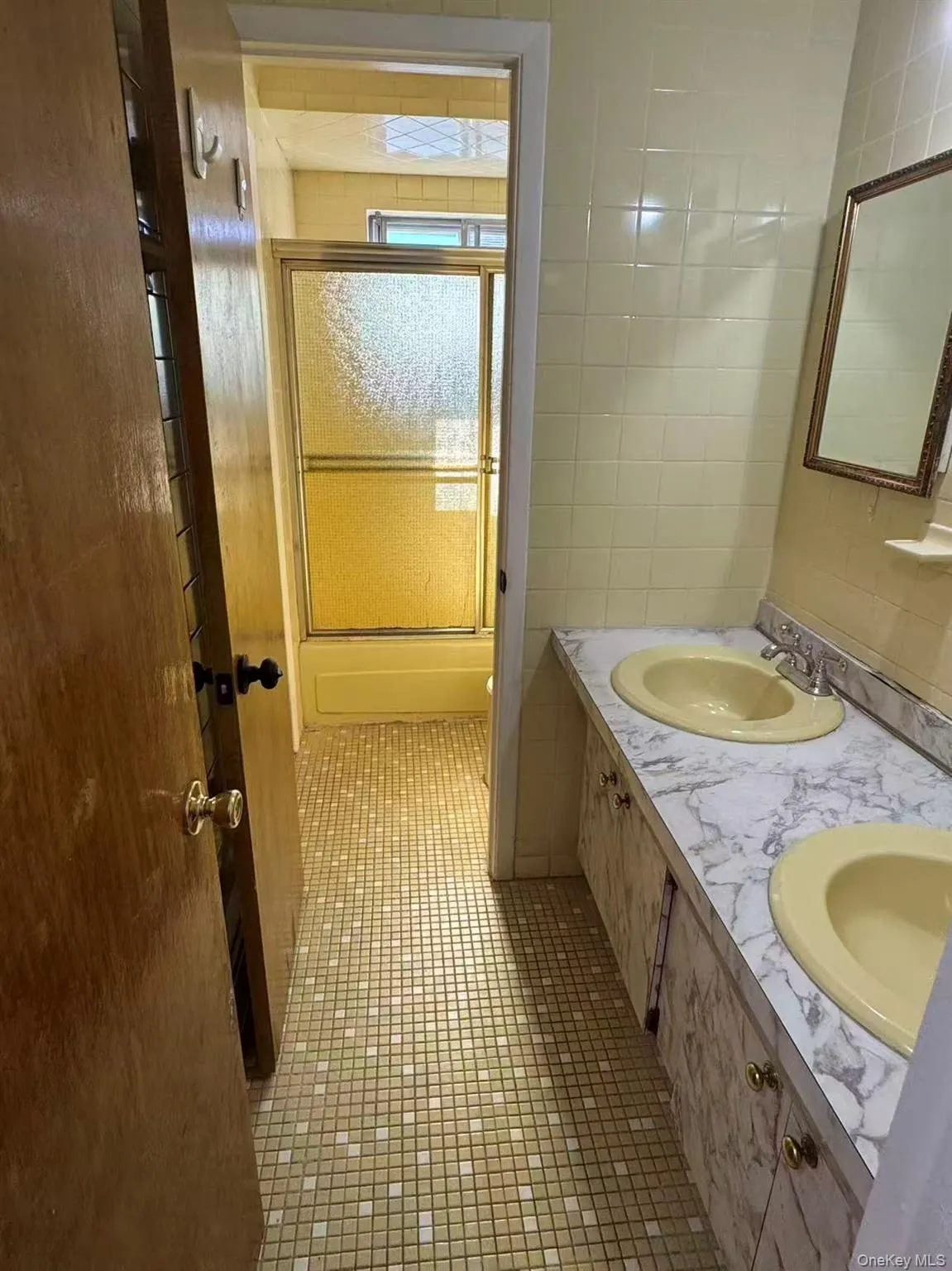 Full bathroom with dark tile patterned flooring, double vanity, and tile walls Full bathroom with dark tile patterned flooring, double vanity, and tile walls