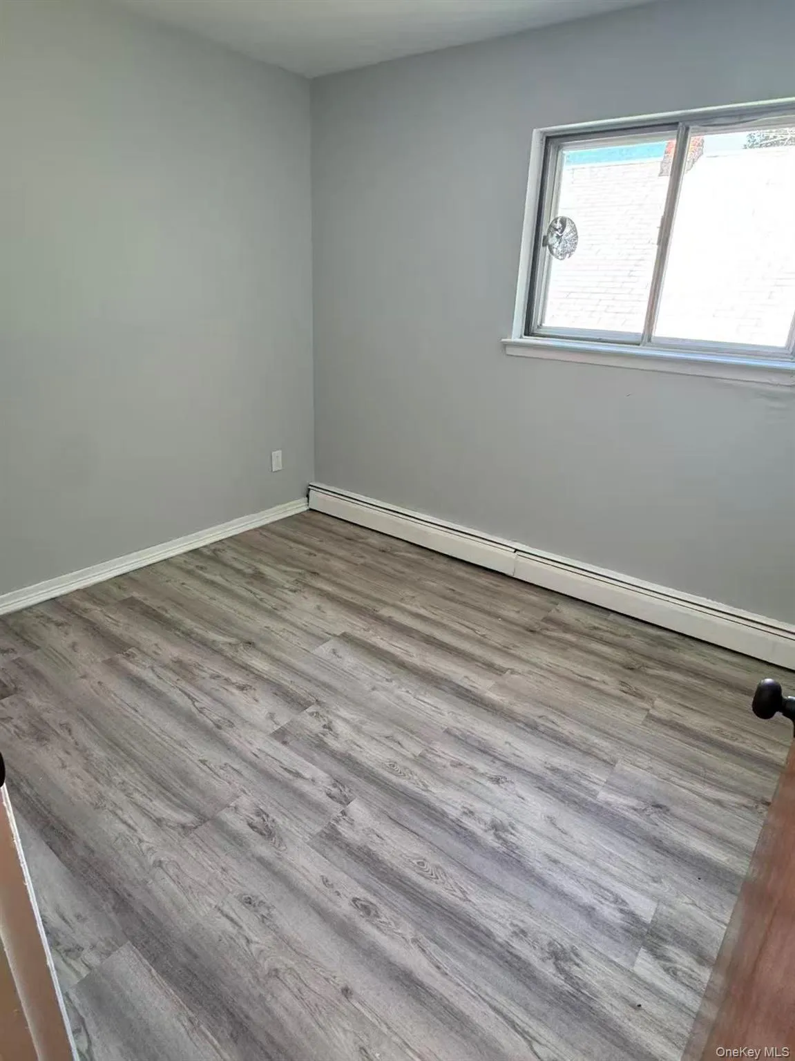 Spare room with a baseboard heating unit and light wood-type flooring Spare room with a baseboard heating unit and light wood-type flooring