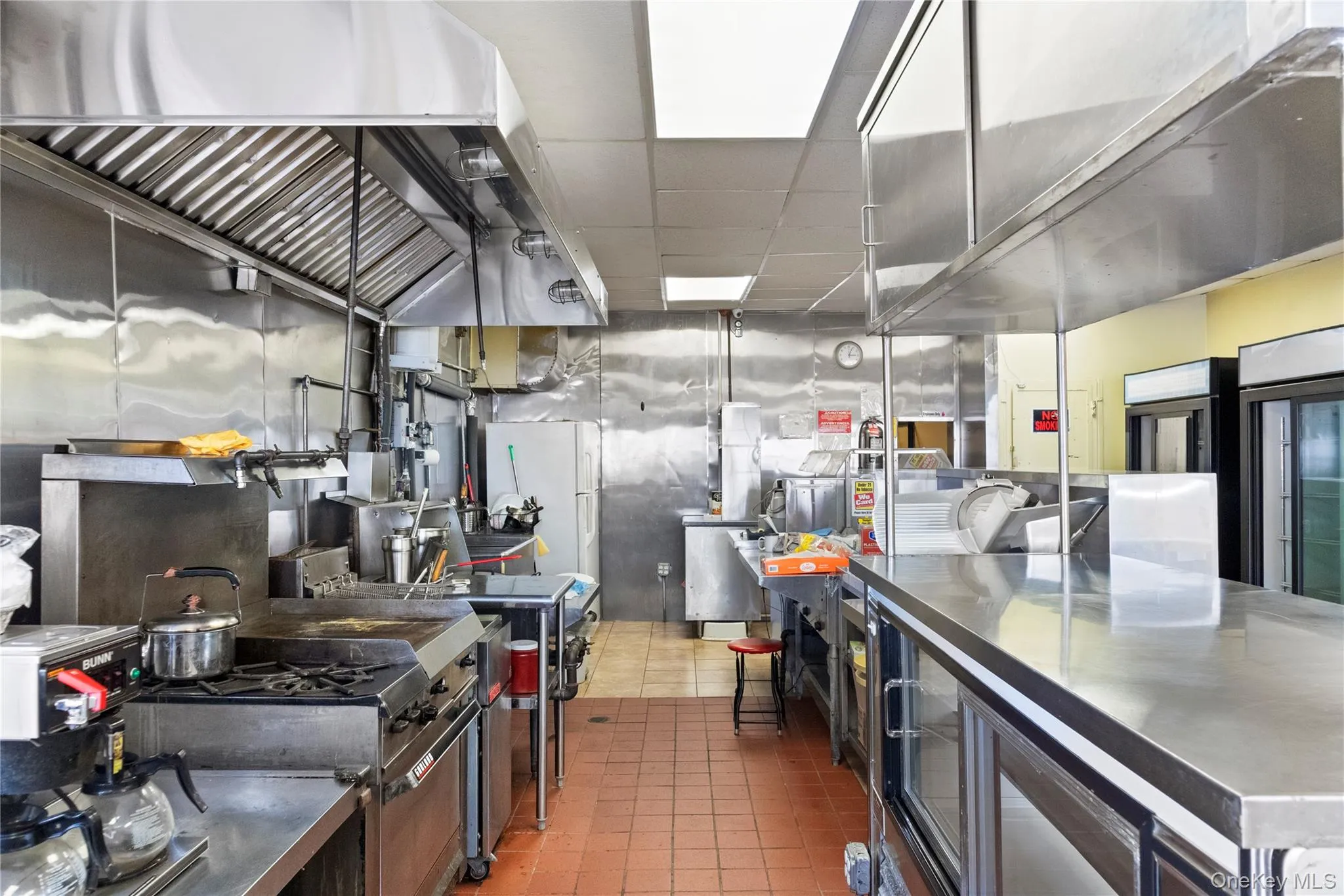 Kitchen with exhaust hood, freestanding refrigerator, and a paneled ceiling Kitchen with exhaust hood, freestanding refrigerator, and a paneled ceiling