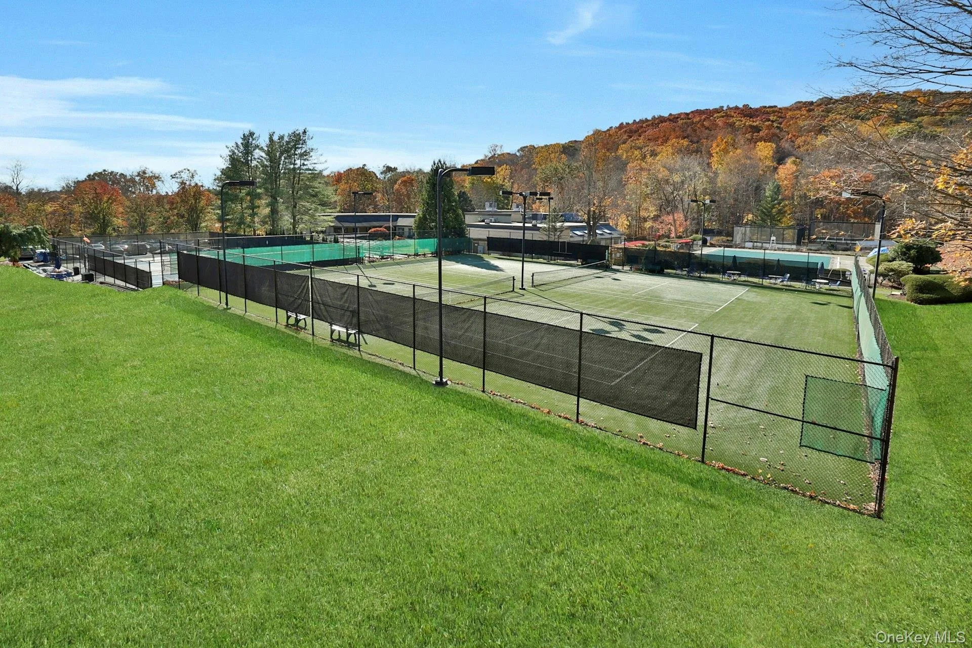 View of two artificial grass lighted tennis courts. Six tennis courts in total. View of two artificial grass lighted tennis courts. Six tennis courts in total.