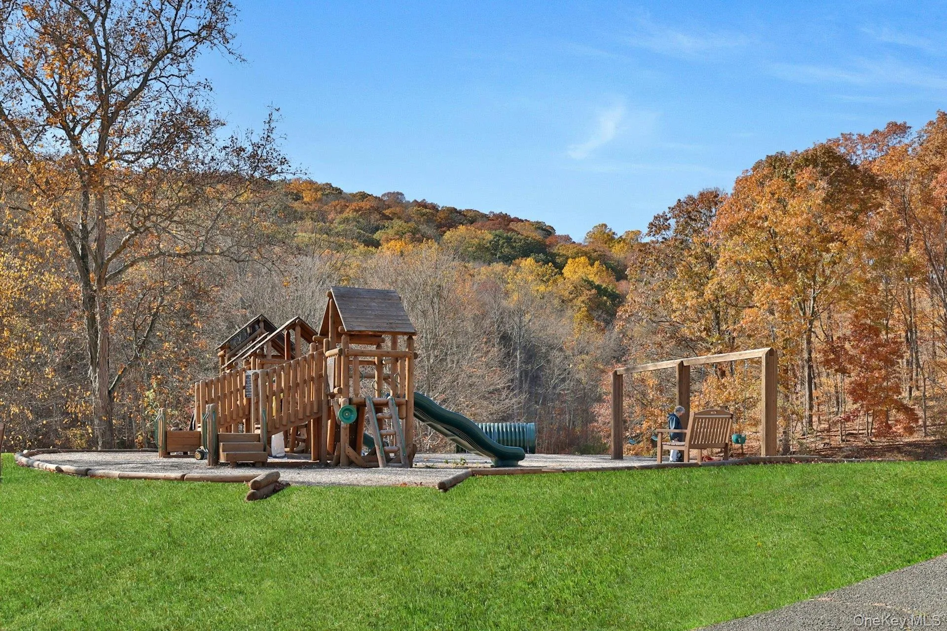 View of jungle gym featuring a yard and a view of trees View of jungle gym featuring a yard and a view of trees