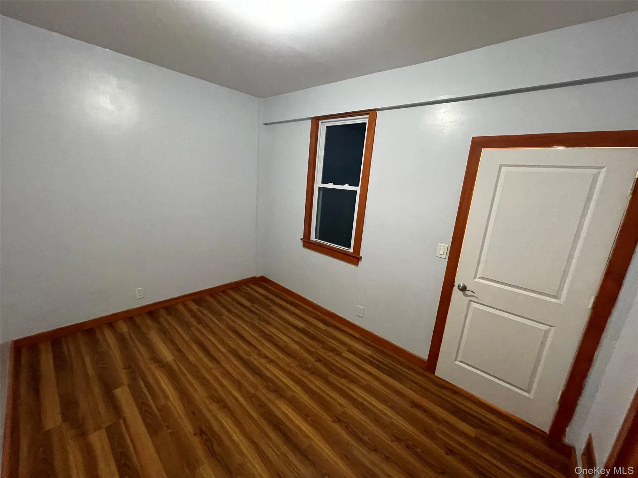 Spare room with wood finished floors and baseboards Spare room with wood finished floors and baseboards