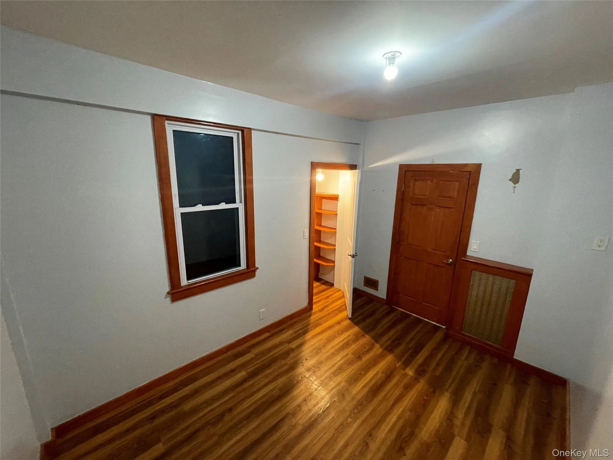 Unfurnished bedroom with dark wood-style floors Unfurnished bedroom with dark wood-style floors