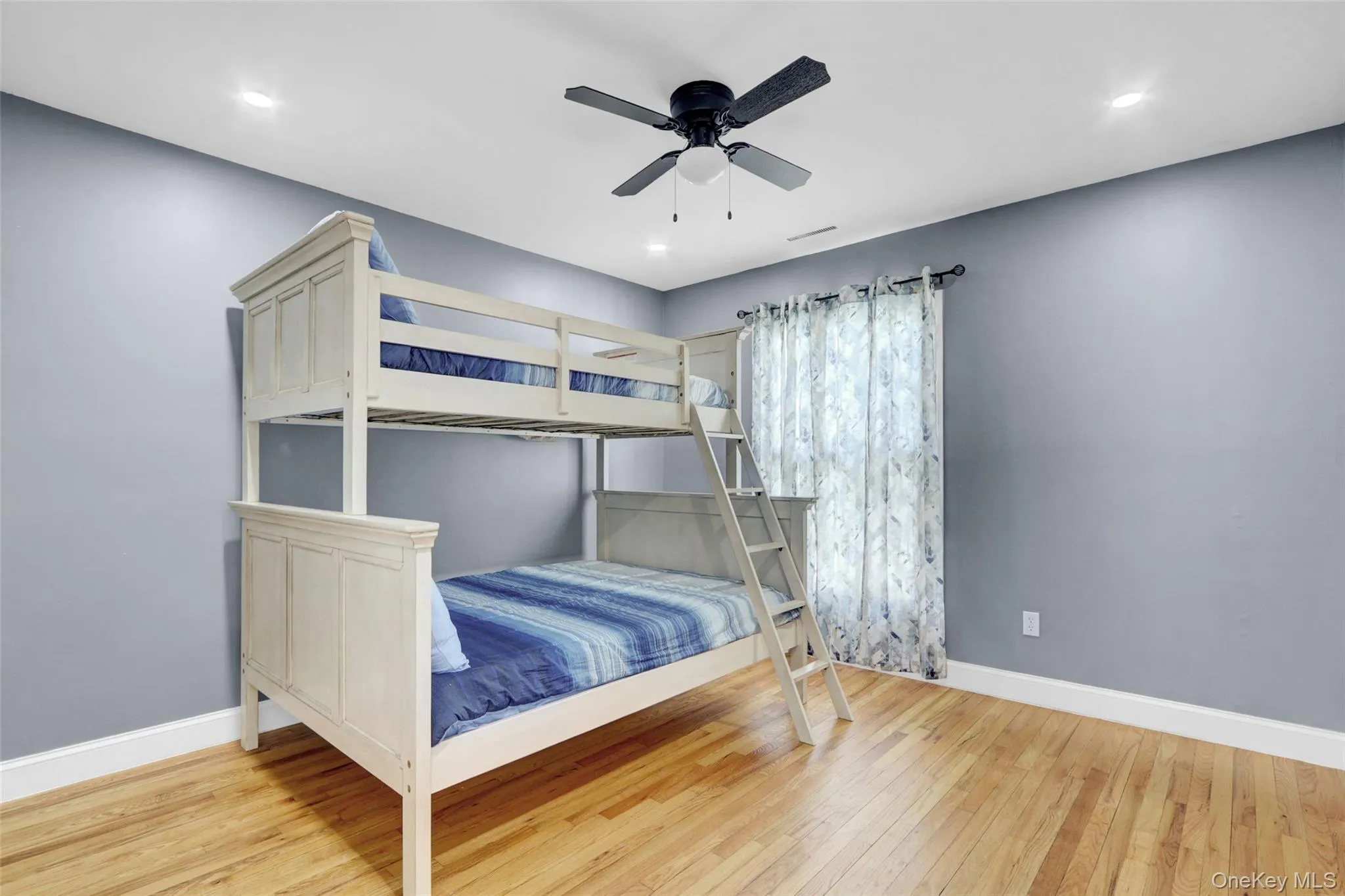 Bedroom 2 with light wood-style floors and a ceiling fan Bedroom 2 with light wood-style floors and a ceiling fan