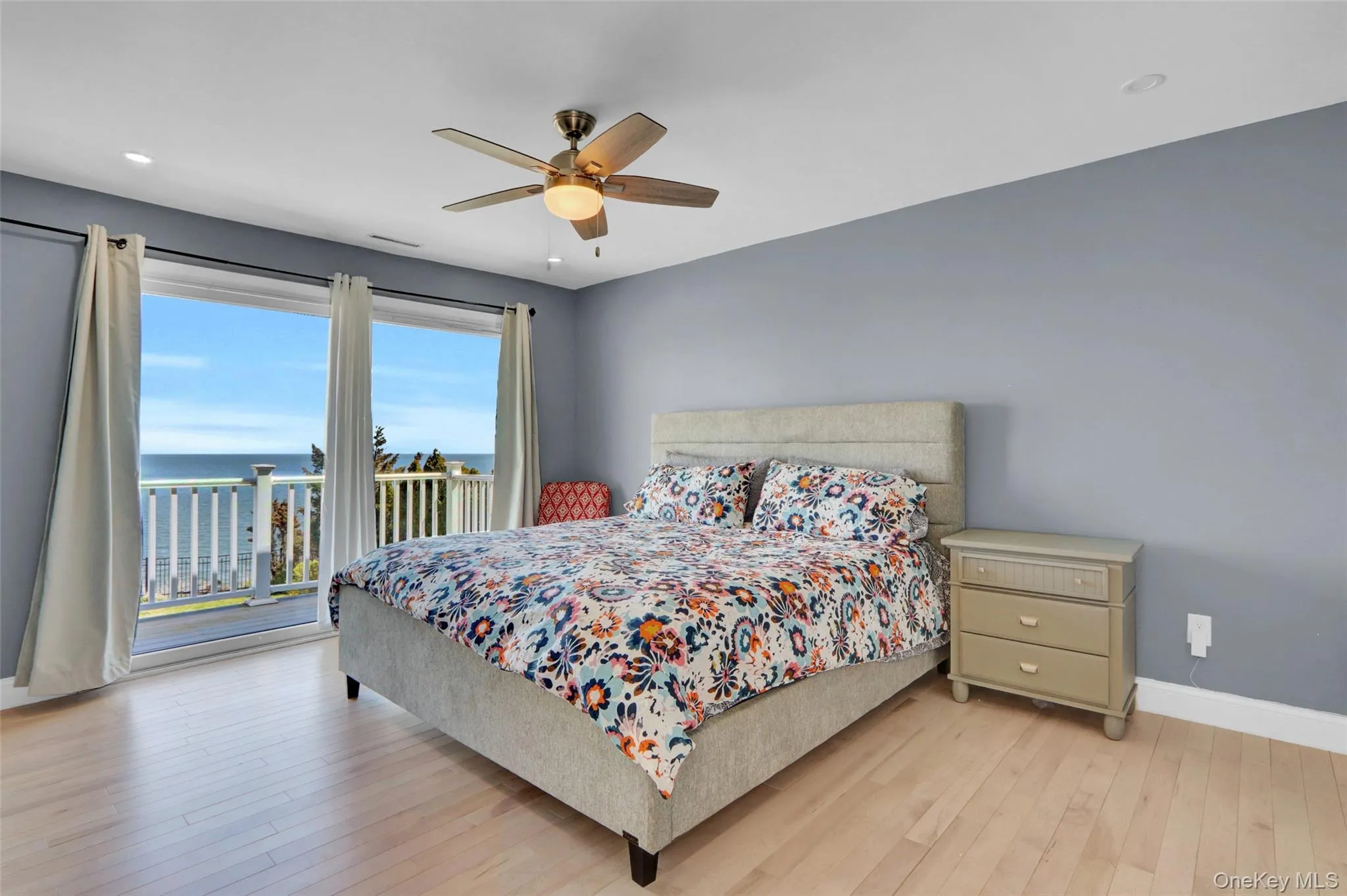 Bedroom with access to outside, a water view, light wood finished floors, and ceiling fan Bedroom with access to outside, a water view, light wood finished floors, and ceiling fan