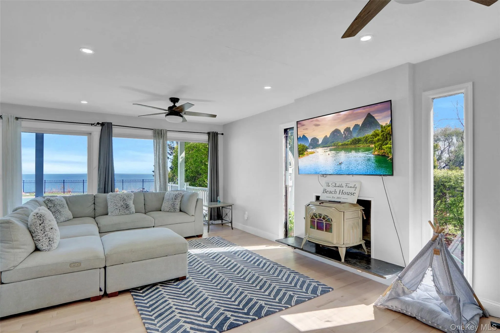 Living area featuring a ceiling fan, a wood stove, wood finished floors, and recessed lighting Living area featuring a ceiling fan, a wood stove, wood finished floors, and recessed lighting