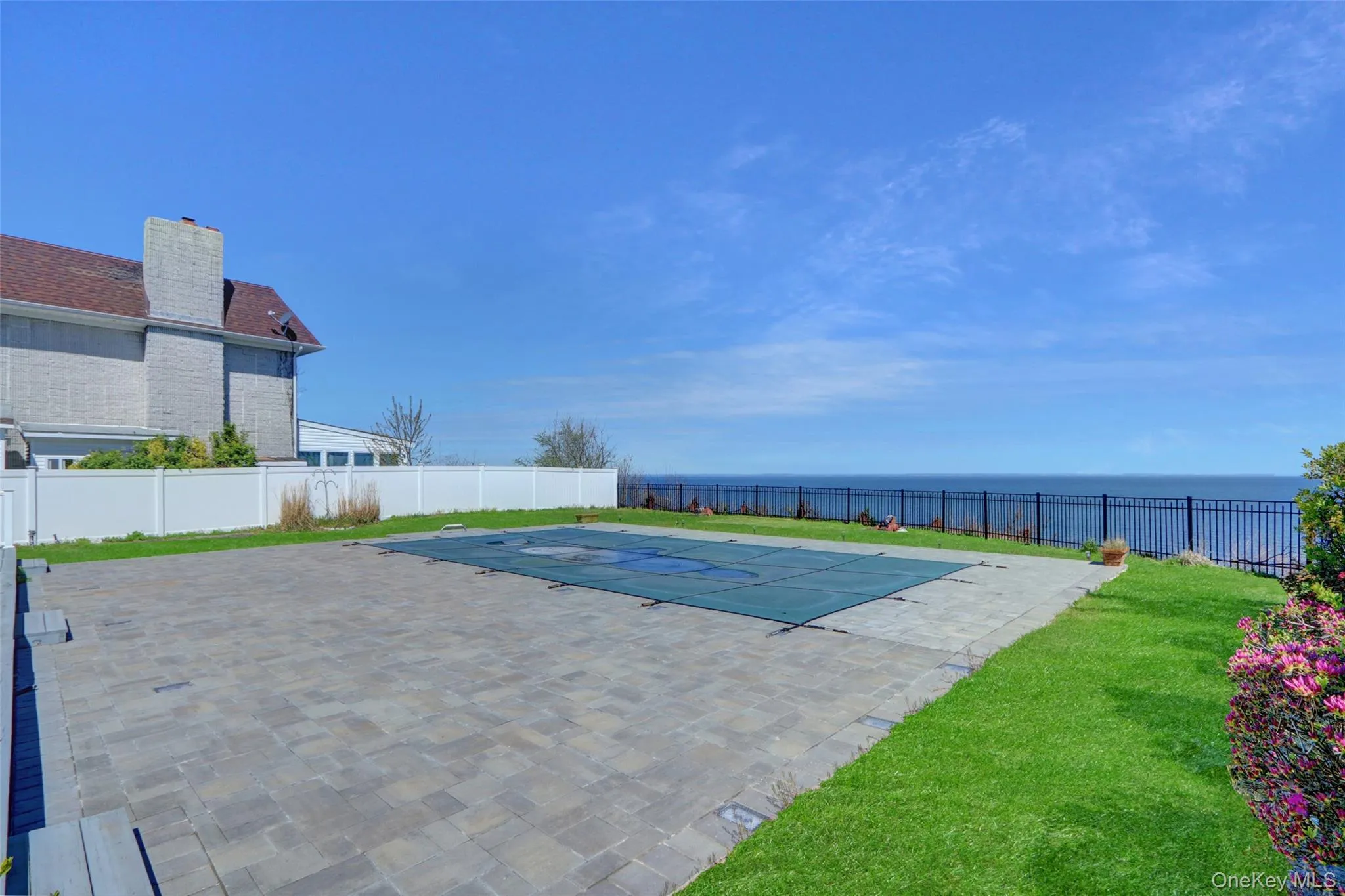 View of pool featuring a water view, a fenced backyard, and a patio area View of pool featuring a water view, a fenced backyard, and a patio area