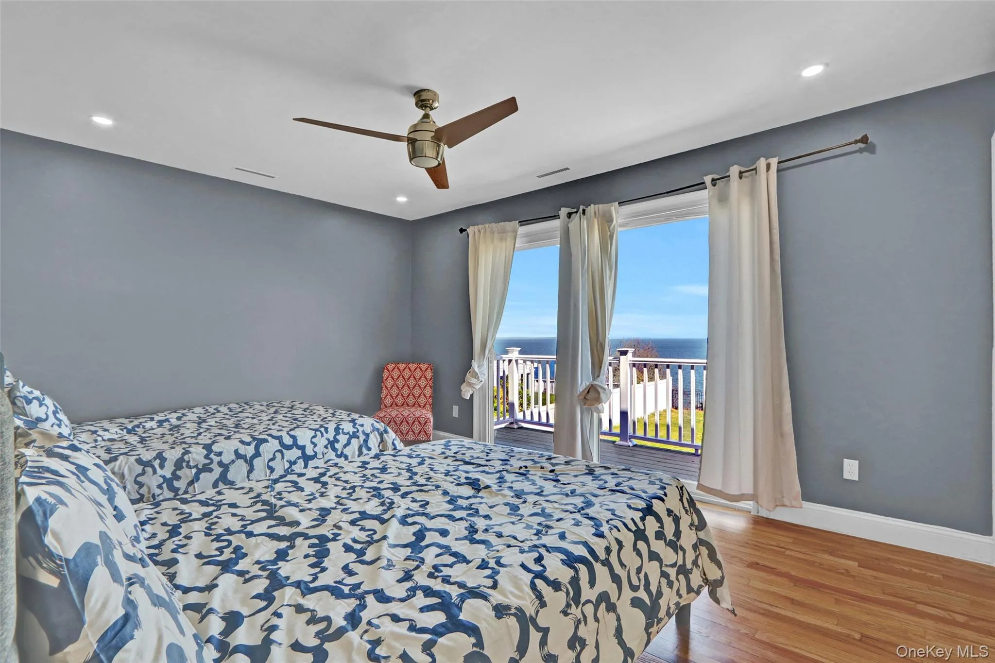 Bedroom 3 featuring a water view, wood finished floors, access to exterior, a ceiling fan, and recessed lighting Bedroom 3 featuring a water view, wood finished floors, access to exterior, a ceiling fan, and recessed lighting