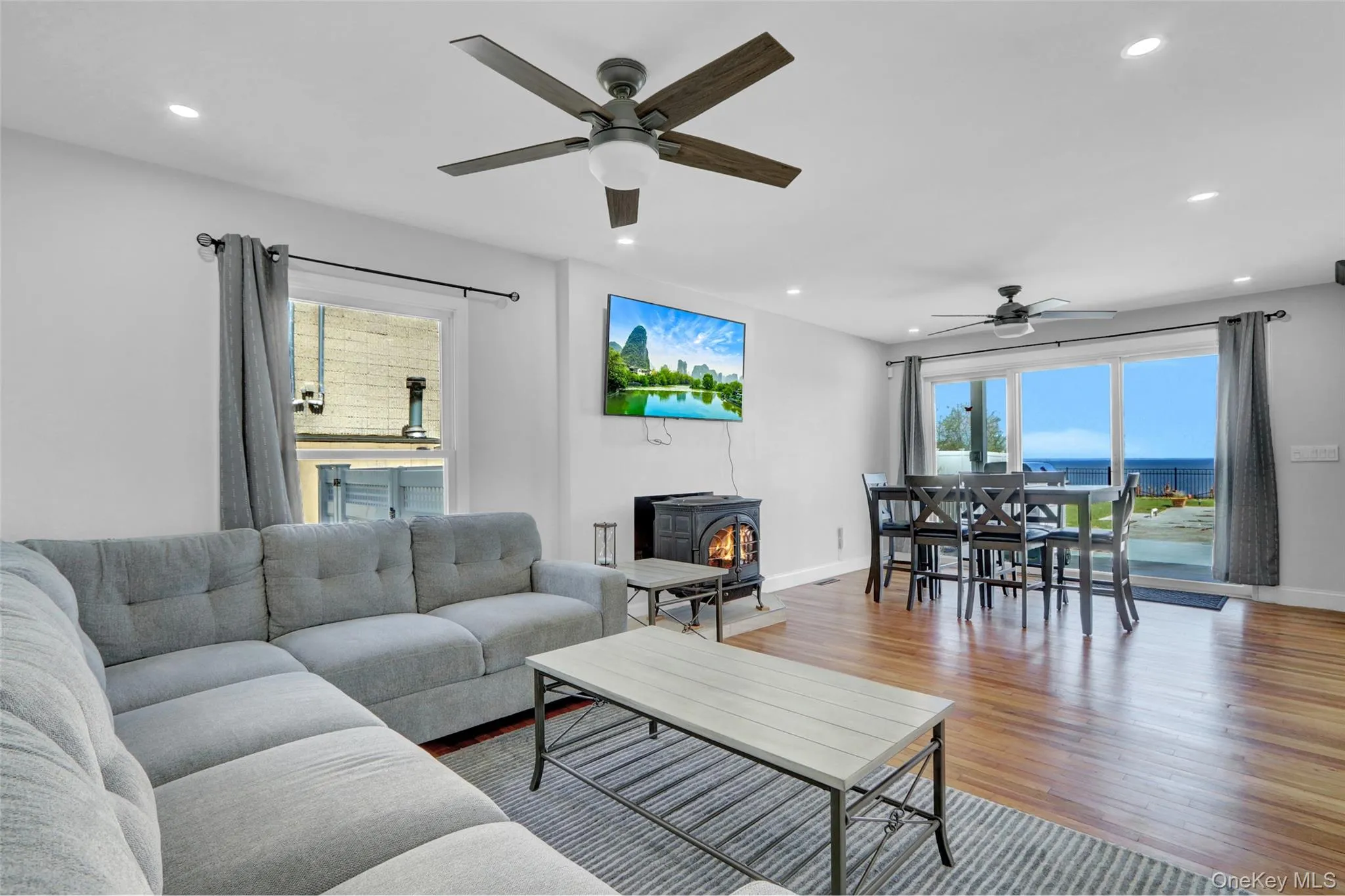 Living area featuring a wood stove, healthy amount of natural light, recessed lighting, and wood finished floors Living area featuring a wood stove, healthy amount of natural light, recessed lighting, and wood finished floors