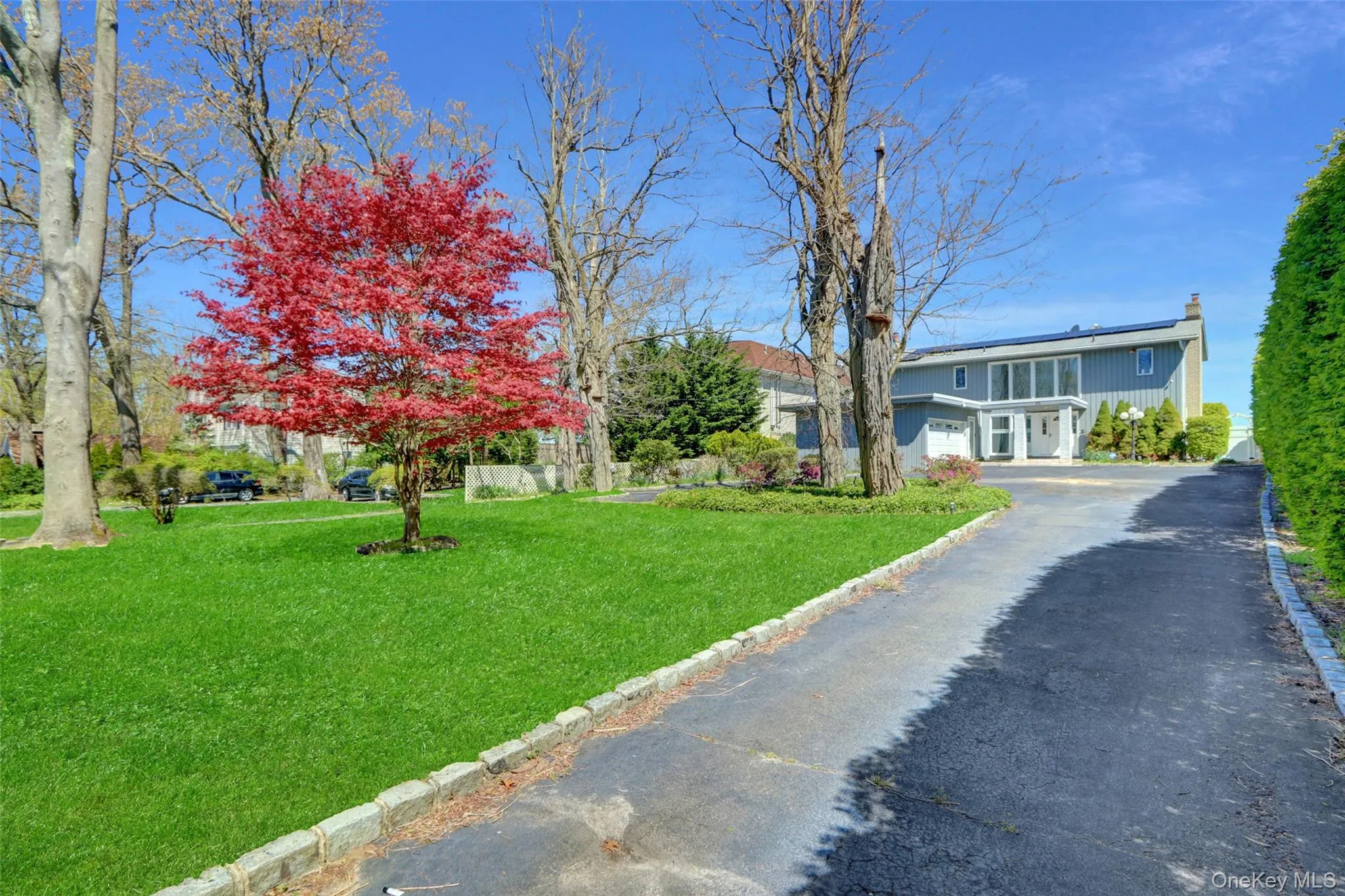 View of front of house featuring a garage, a front yard, and a chimney View of front of house featuring a garage, a front yard, and a chimney