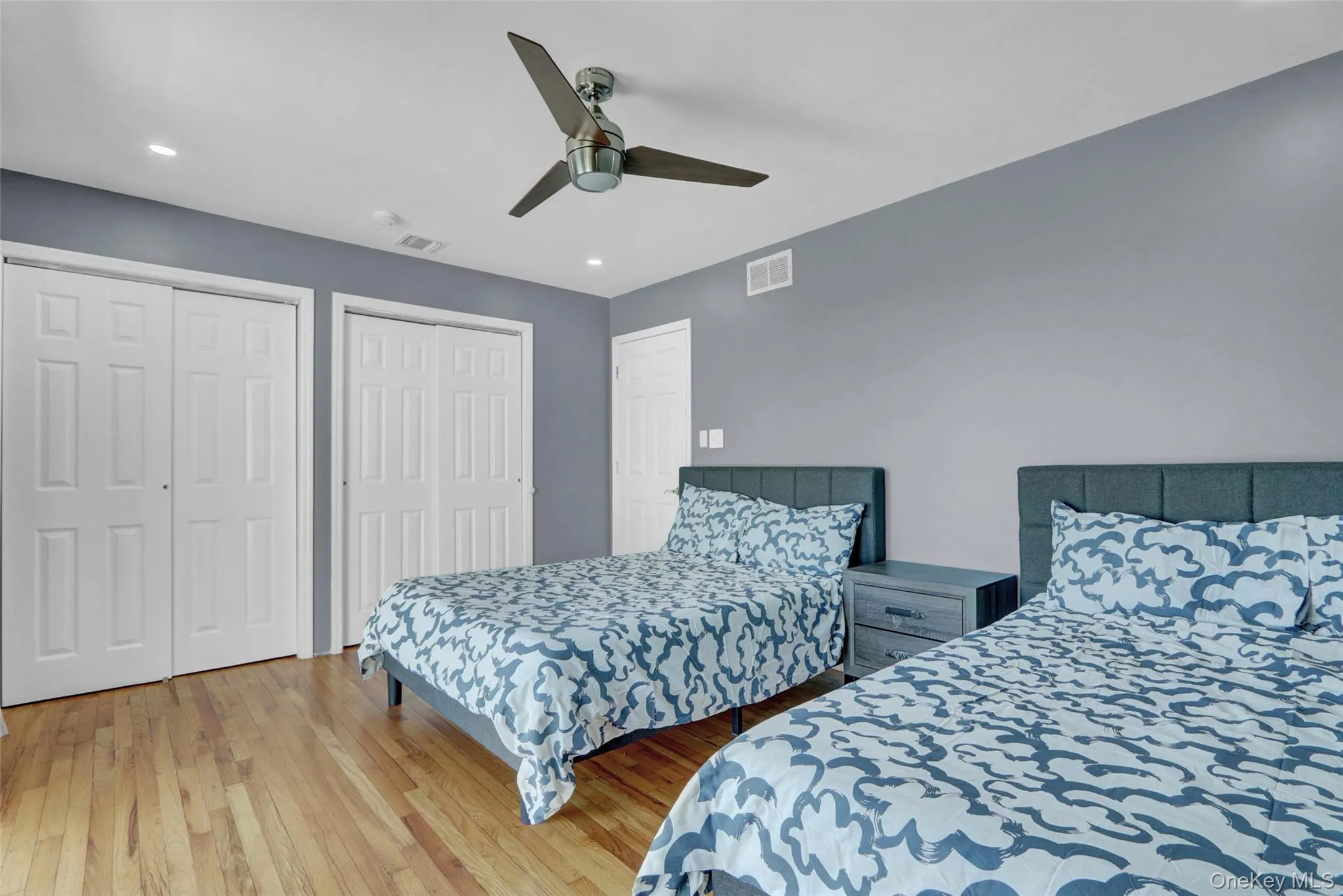 Bedroom 4 with wood finished floors, two closets, ceiling fan, and recessed lighting Bedroom 4 with wood finished floors, two closets, ceiling fan, and recessed lighting