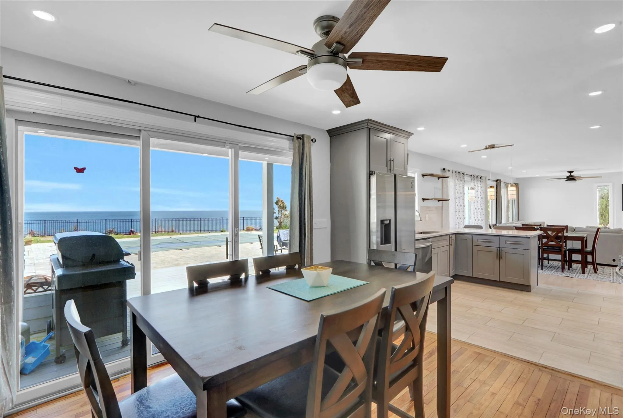 Dining area with a ceiling fan, light wood finished floors, recessed lighting, and a water view Dining area with a ceiling fan, light wood finished floors, recessed lighting, and a water view