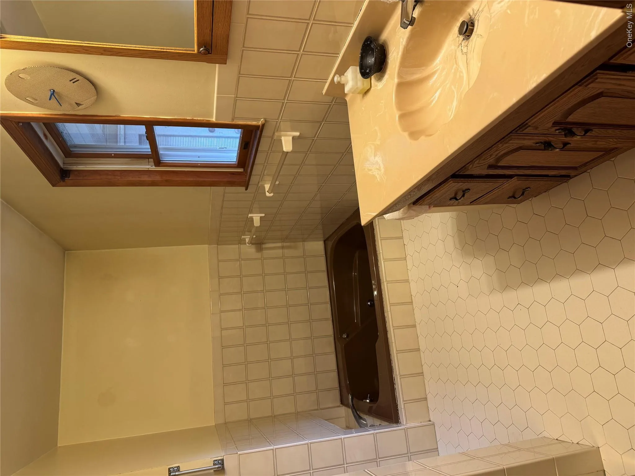 Bathroom featuring vanity, a bath, tile walls, and a wainscoted wall Bathroom featuring vanity, a bath, tile walls, and a wainscoted wall