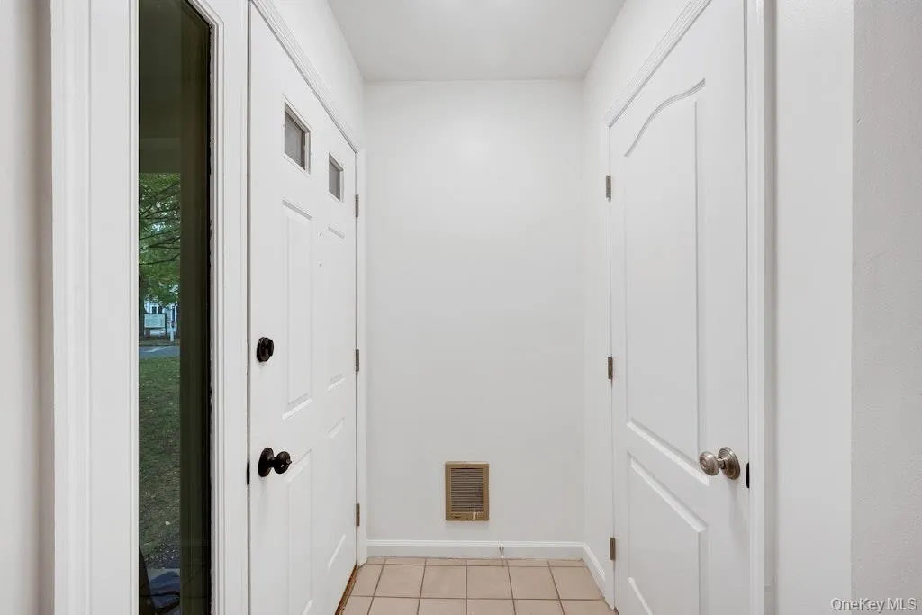 Doorway featuring tile patterned floors and baseboards Doorway featuring tile patterned floors and baseboards