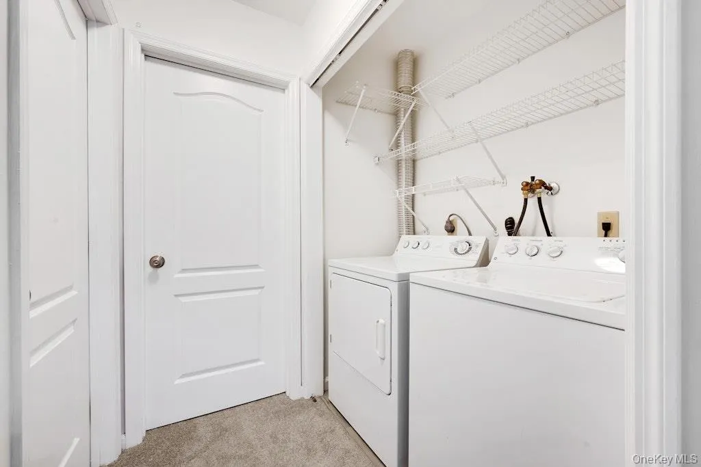Laundry room featuring light carpet and separate washer and dryer Laundry room featuring light carpet and separate washer and dryer