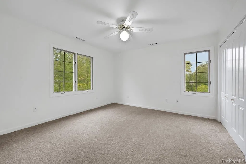 Empty room with light colored carpet and ceiling fan Empty room with light colored carpet and ceiling fan