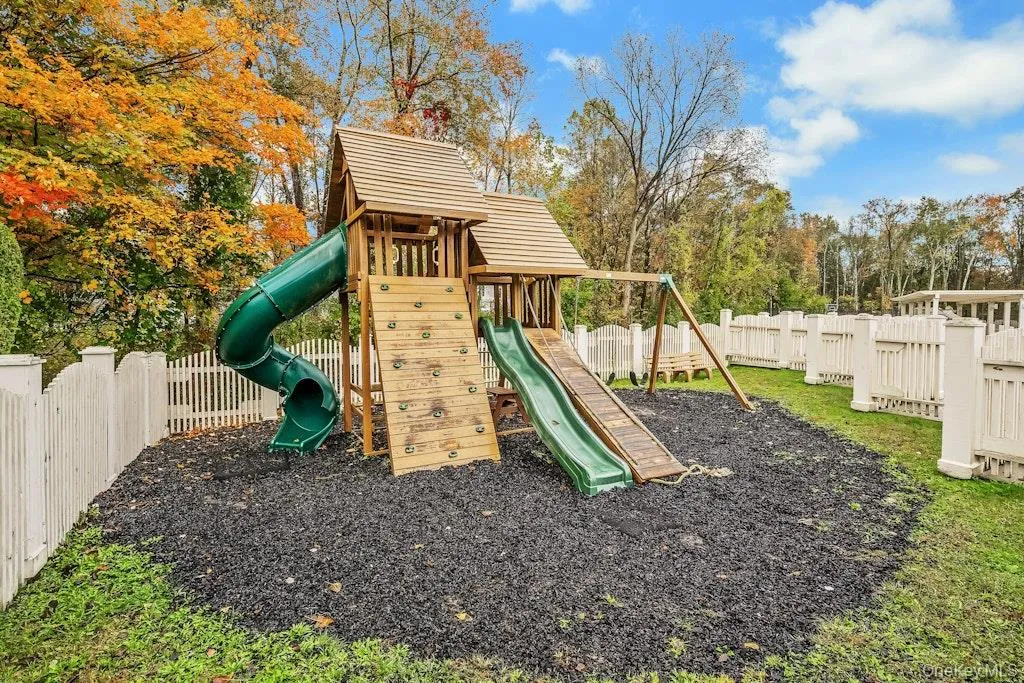 View of playground with a fenced backyard and view of wooded area View of playground with a fenced backyard and view of wooded area