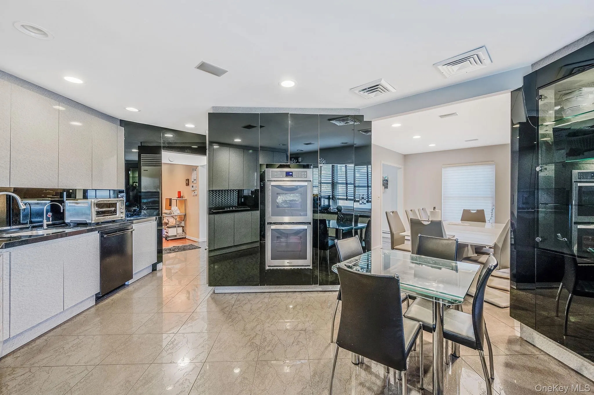 Kitchen with appliances with stainless steel finishes, modern cabinets, recessed lighting, and gray cabinetry Kitchen with appliances with stainless steel finishes, modern cabinets, recessed lighting, and gray cabinetry