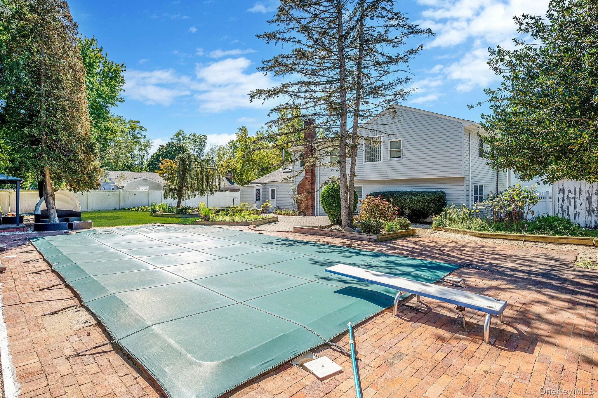 View of pool featuring a fenced backyard, a patio, and a diving board View of pool featuring a fenced backyard, a patio, and a diving board