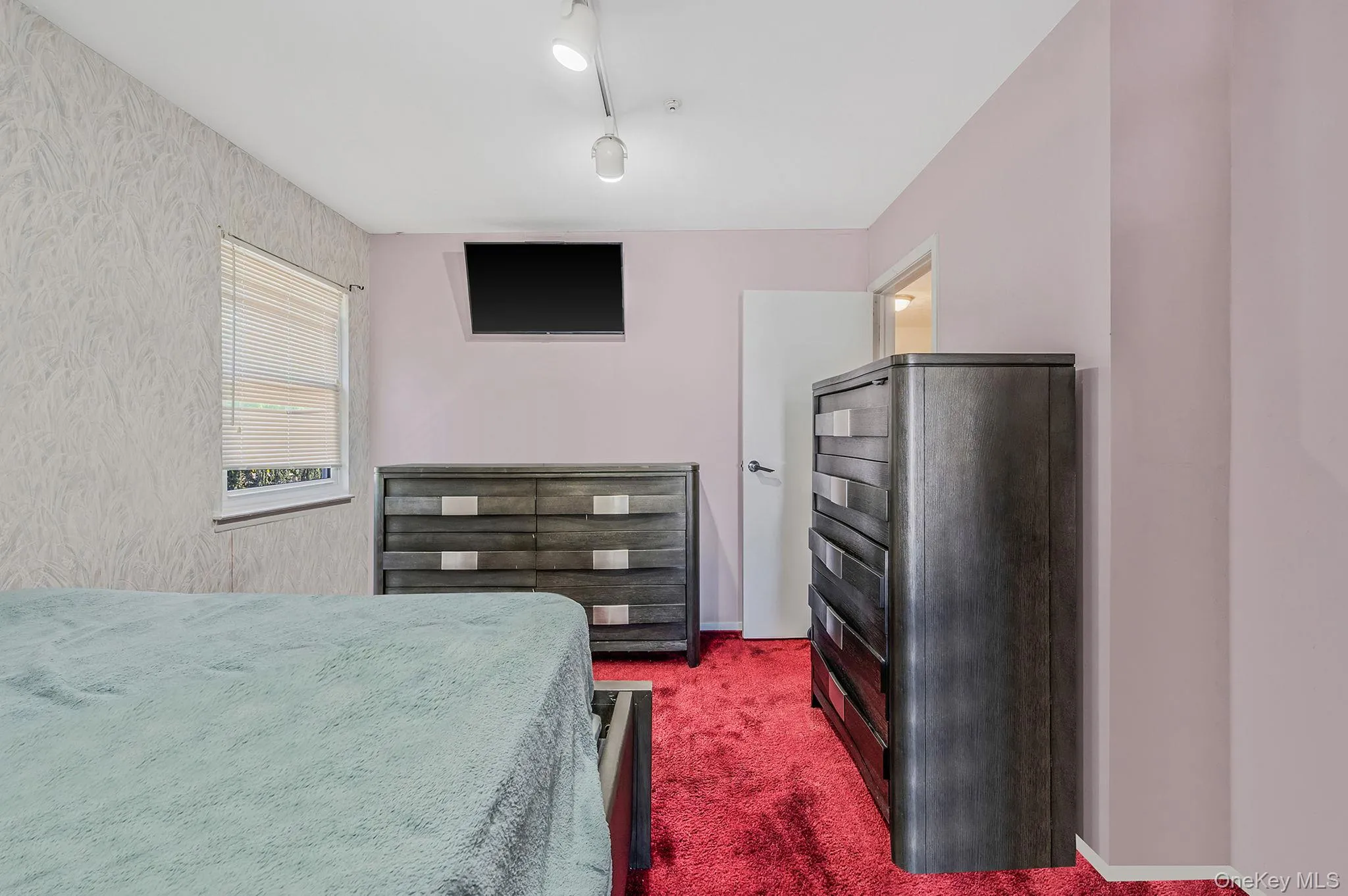 Bedroom featuring dark colored carpet and baseboards Bedroom featuring dark colored carpet and baseboards