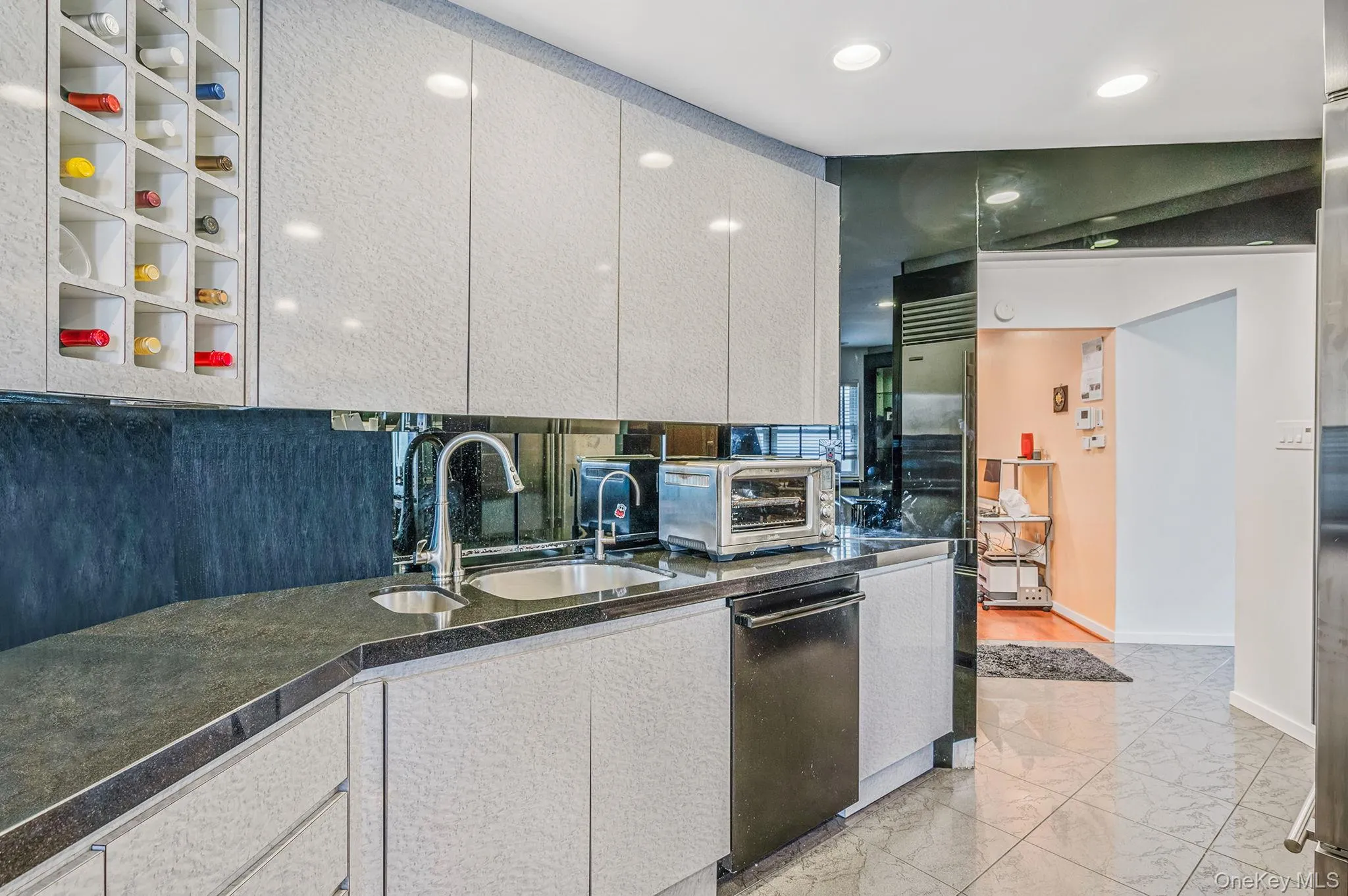 Kitchen with dishwasher, light marble finish floors, recessed lighting, refrigerator, and dark stone countertops Kitchen with dishwasher, light marble finish floors, recessed lighting, refrigerator, and dark stone countertops