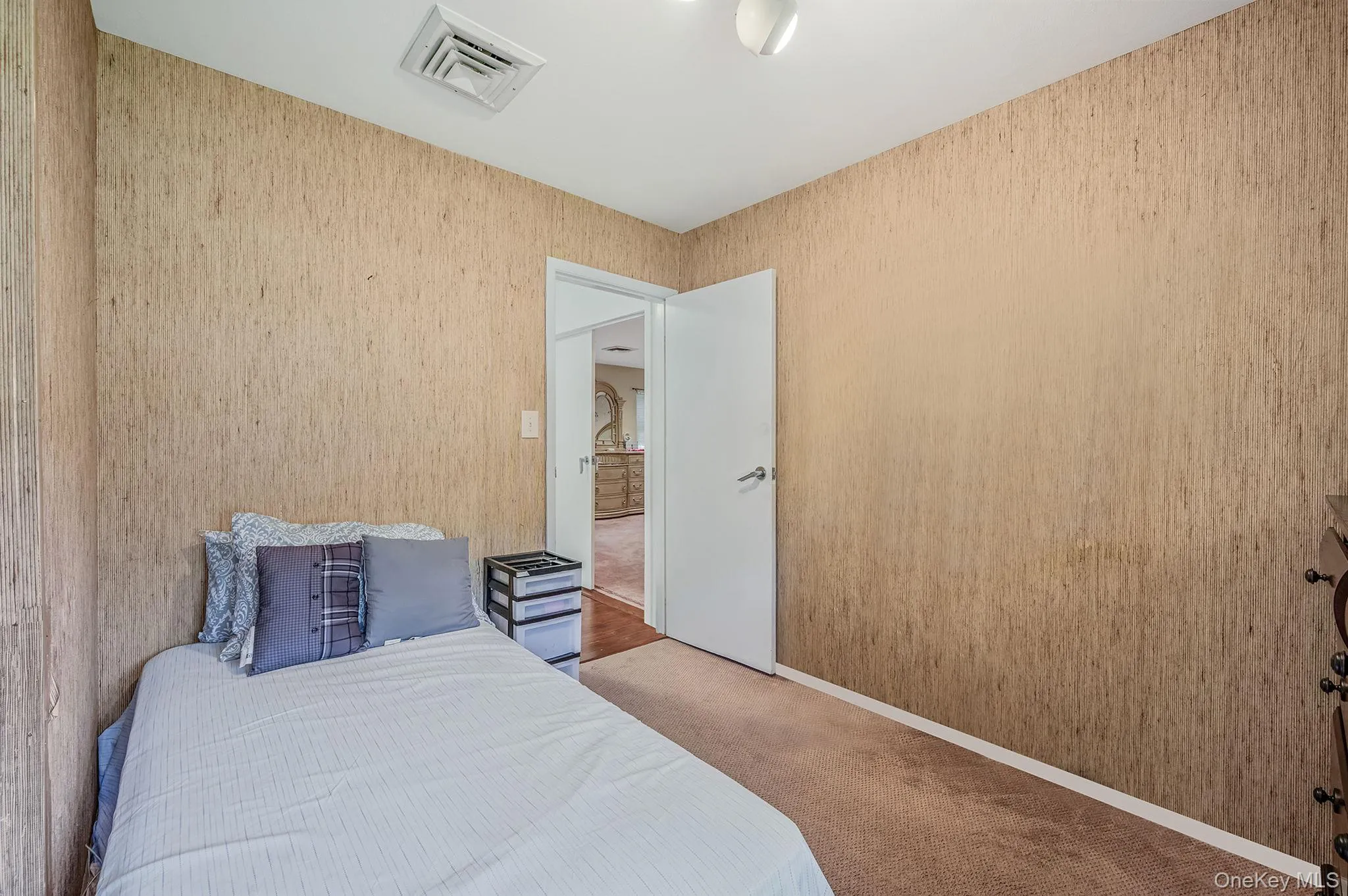 Carpeted bedroom featuring wallpapered walls and baseboards Carpeted bedroom featuring wallpapered walls and baseboards