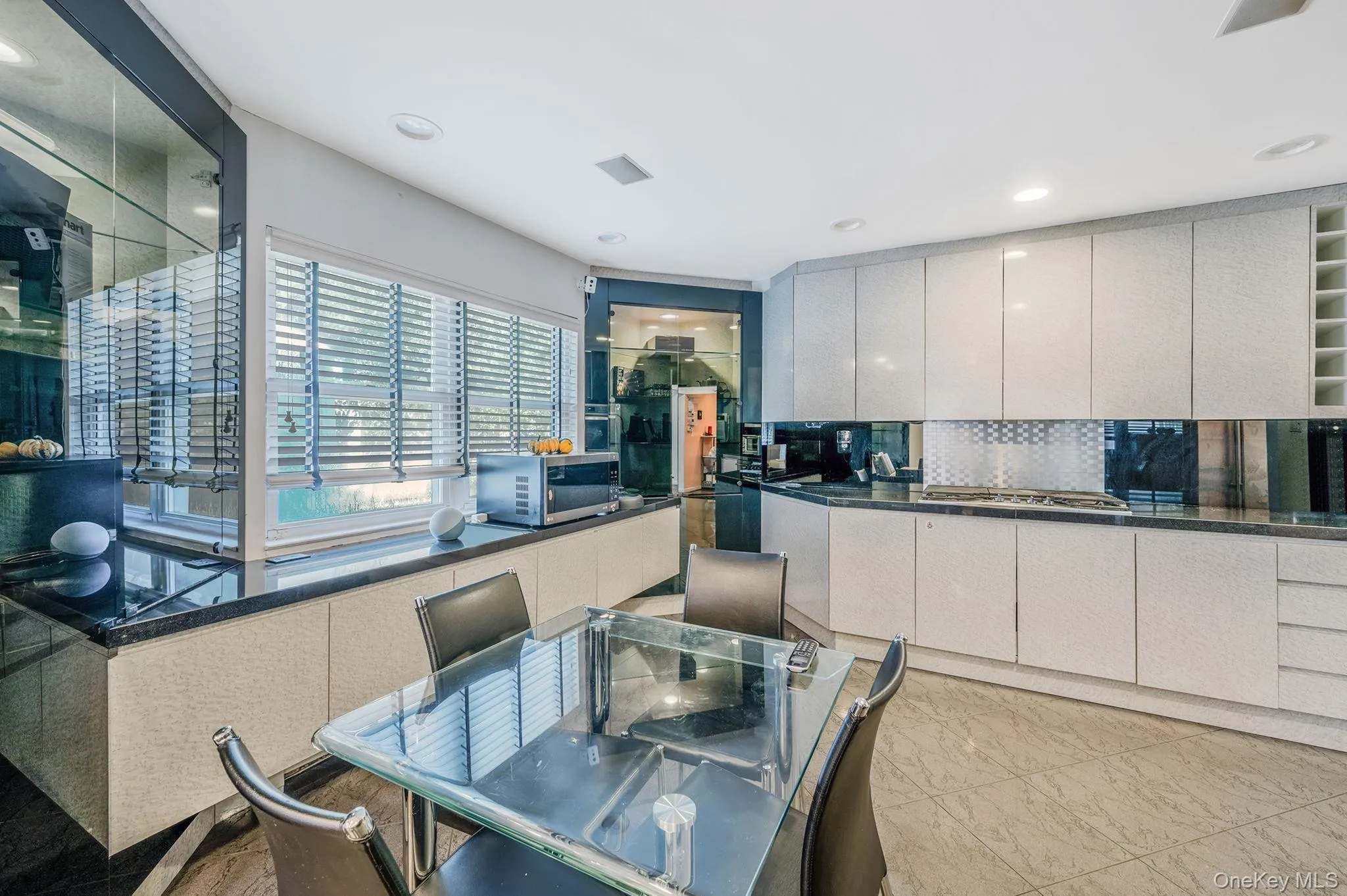 Kitchen with backsplash, modern cabinets, recessed lighting, and stainless steel appliances Kitchen with backsplash, modern cabinets, recessed lighting, and stainless steel appliances