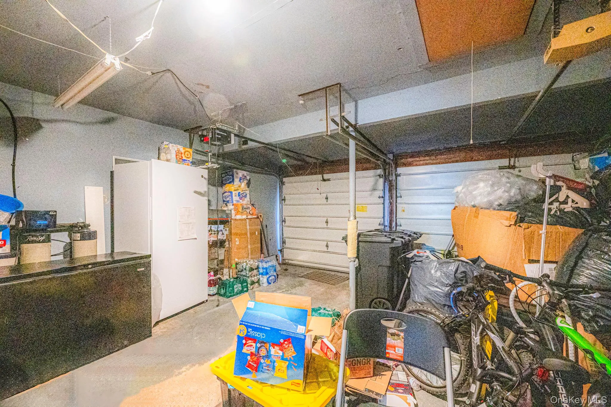 Garage with refrigerator, freestanding refrigerator, and a garage door opener Garage with refrigerator, freestanding refrigerator, and a garage door opener