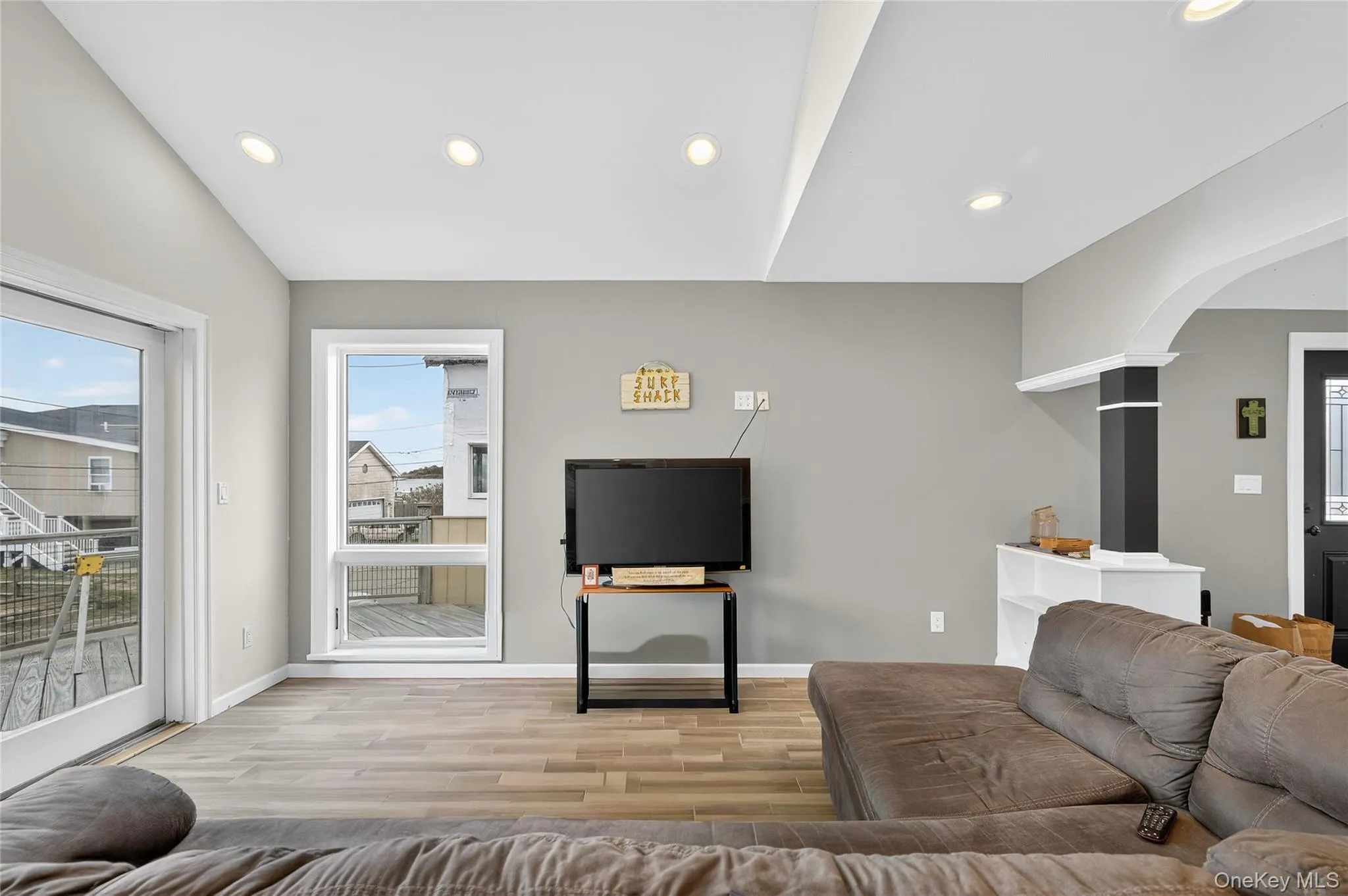 Living room featuring recessed lighting, light wood-type flooring, and arched walkway. Living room featuring recessed lighting, light wood-type flooring, and arched walkway.