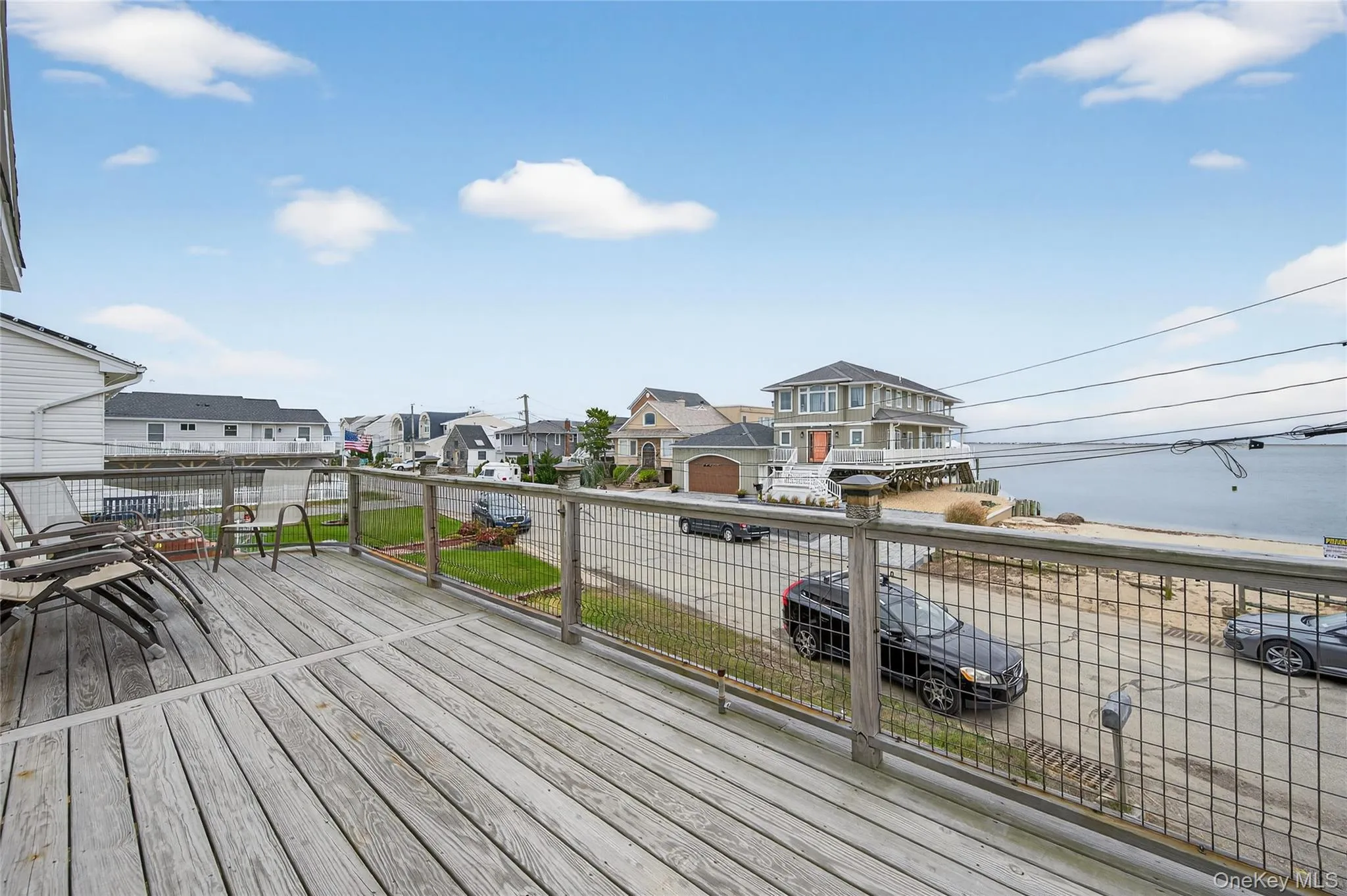 Wooden deck featuring view of Great South Bay and neighborhood Wooden deck featuring view of Great South Bay and neighborhood