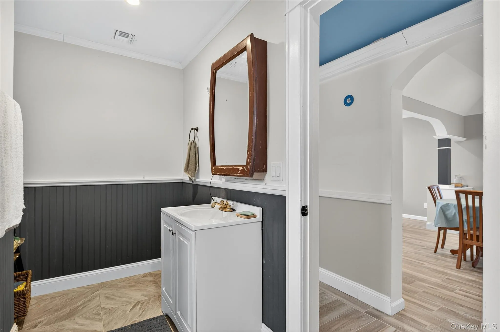 Bathroom with vanity, ornamental molding, and light wood-style flooring Bathroom with vanity, ornamental molding, and light wood-style flooring