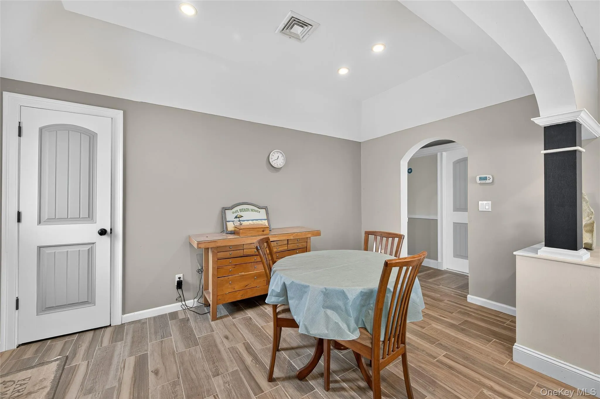 Dining room with arched walkway, wood-type floors, and recessed lighting Dining room with arched walkway, wood-type floors, and recessed lighting