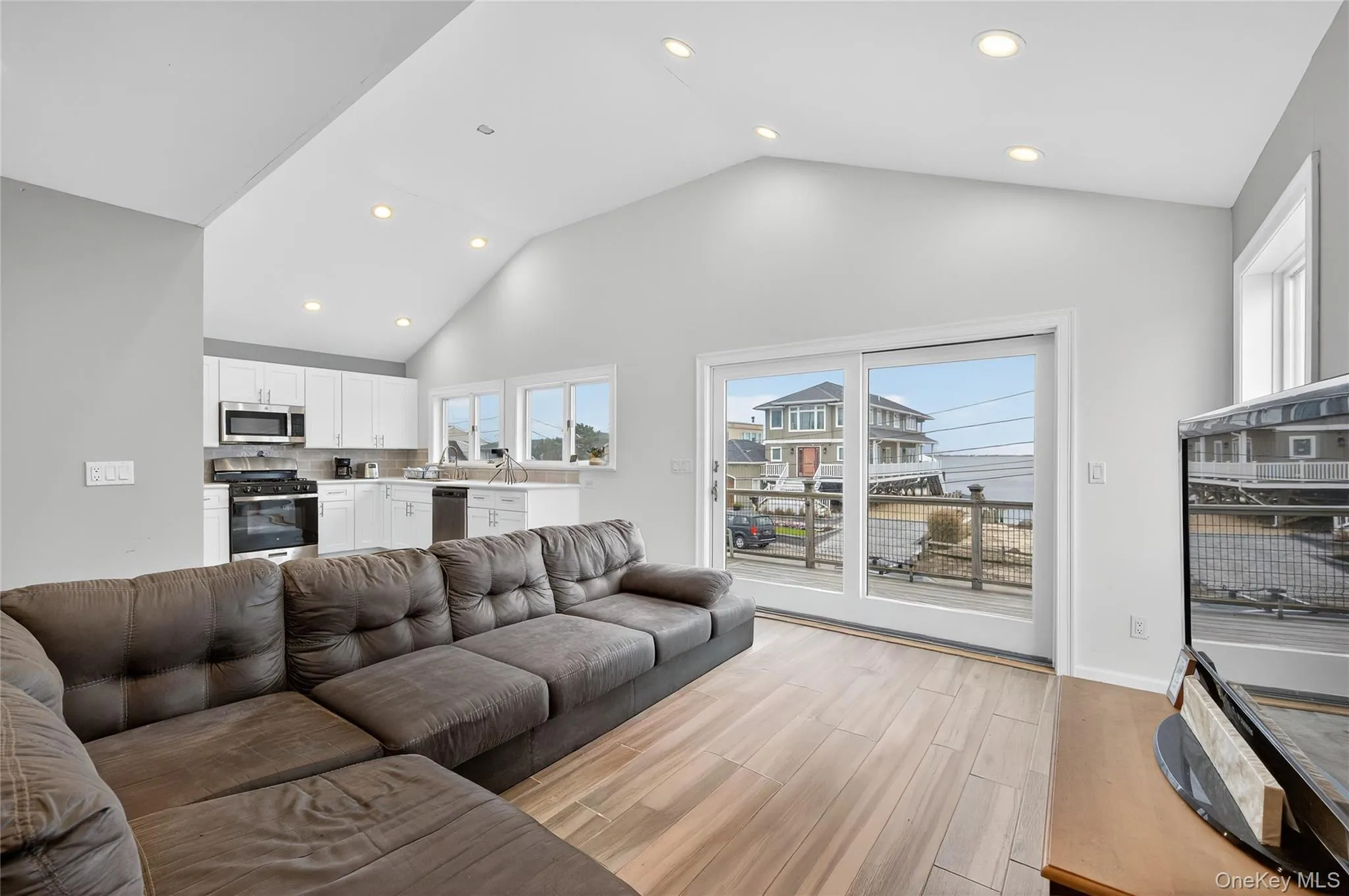 Living room with high vaulted ceiling, and water view Living room with high vaulted ceiling, and water view