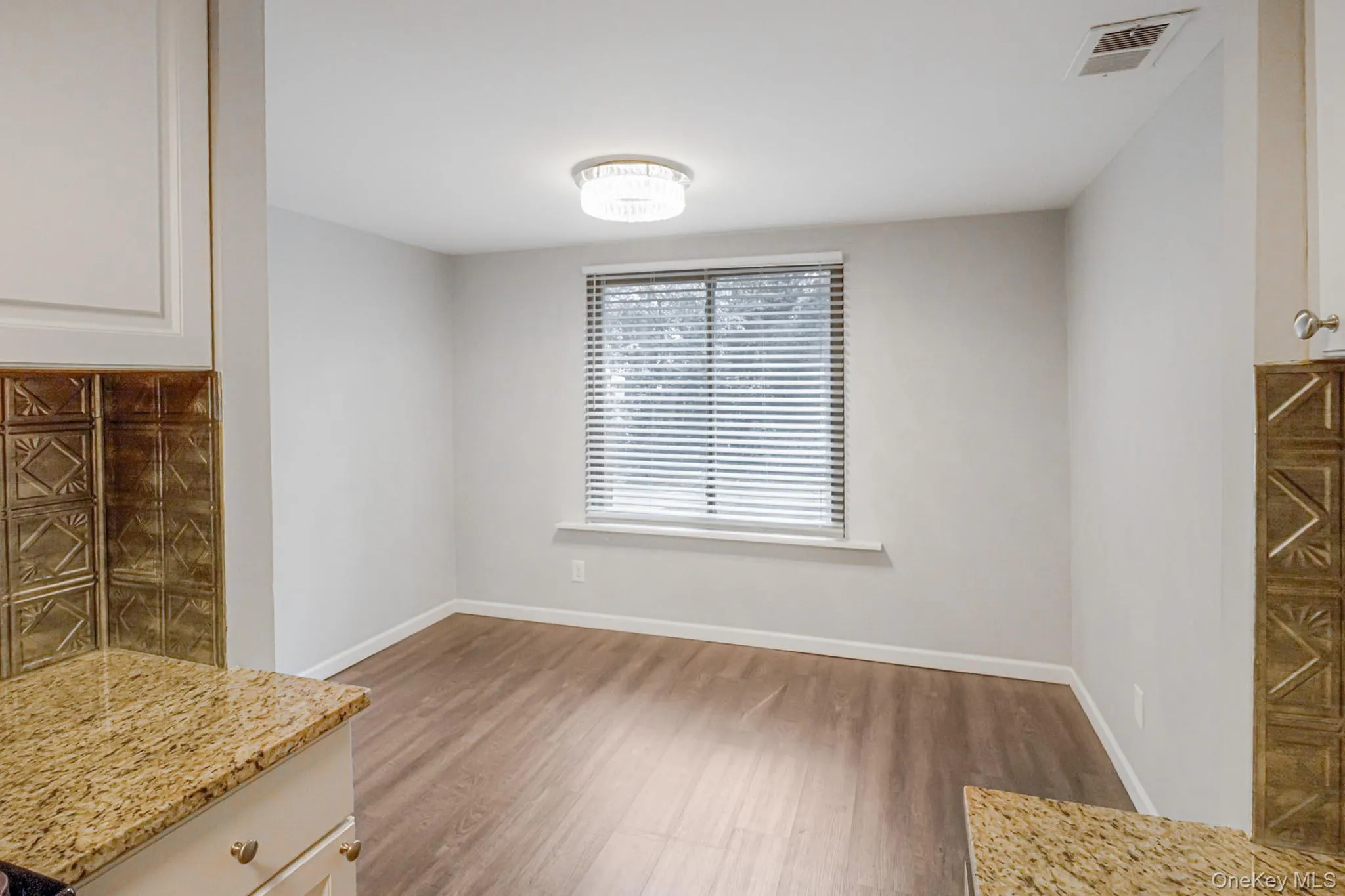 Unfurnished dining area with baseboards and wood finished floors Unfurnished dining area with baseboards and wood finished floors