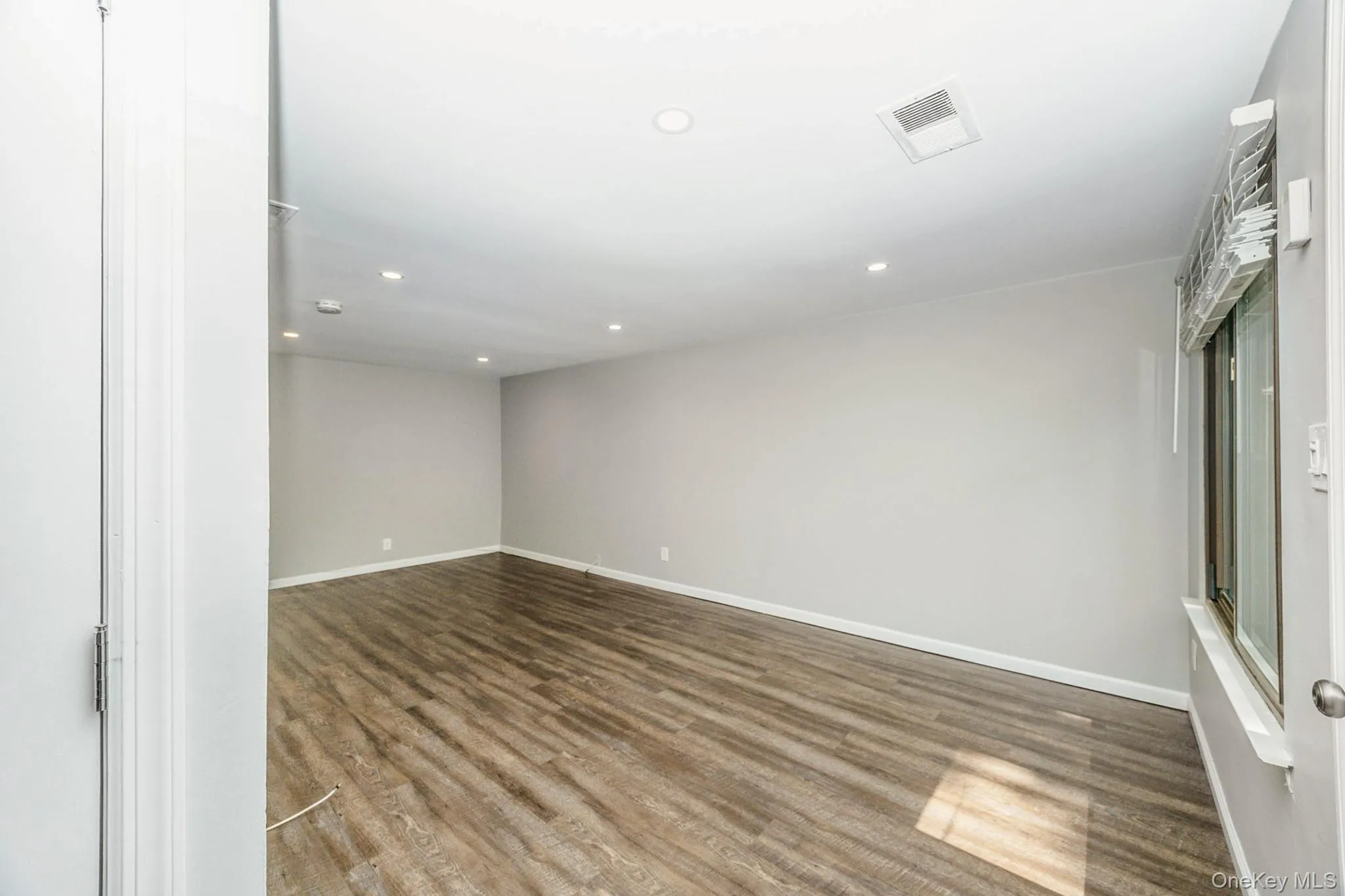 Unfurnished room with dark wood finished floors and recessed lighting Unfurnished room with dark wood finished floors and recessed lighting