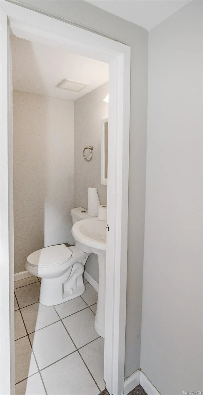 Half bathroom with light tile patterned floors and toilet Half bathroom with light tile patterned floors and toilet