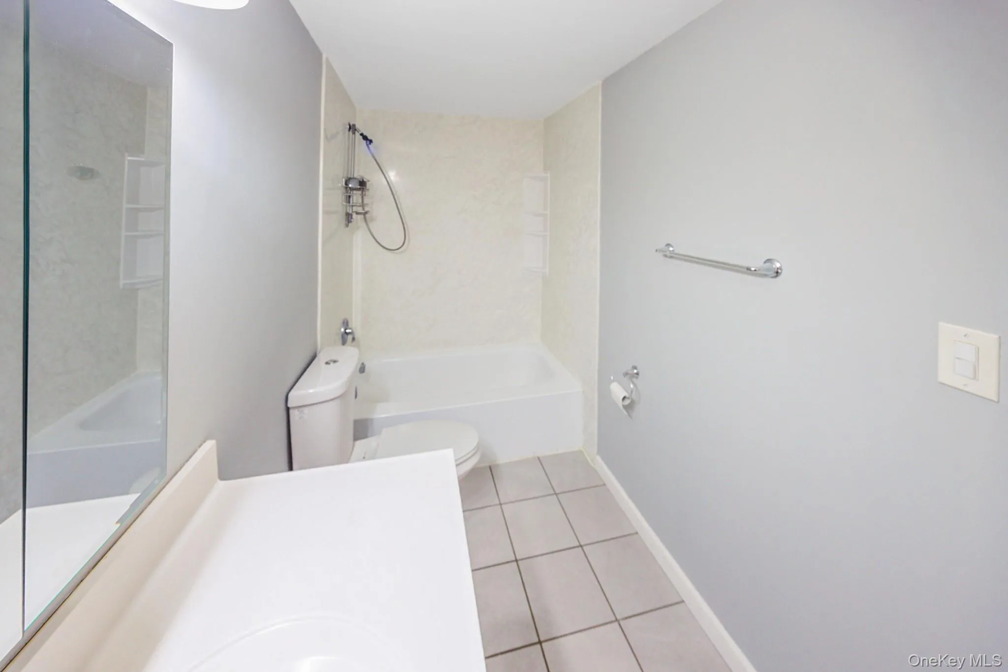 Bathroom featuring light tile patterned floors, bathtub / shower combination, and vanity Bathroom featuring light tile patterned floors, bathtub / shower combination, and vanity