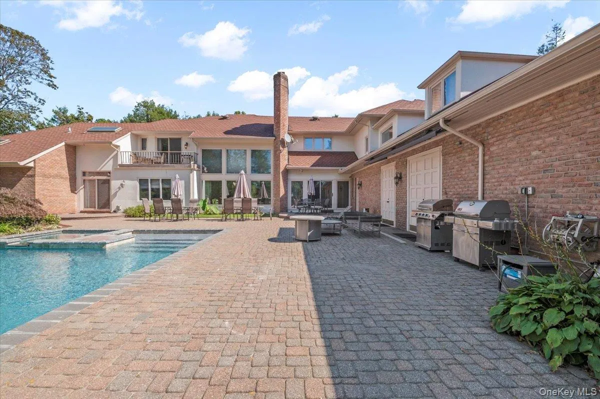 View of swimming pool with a balcony, a patio area, outdoor dining area, area for grilling, and a pool with connected hot tub View of swimming pool with a balcony, a patio area, outdoor dining area, area for grilling, and a pool with connected hot tub