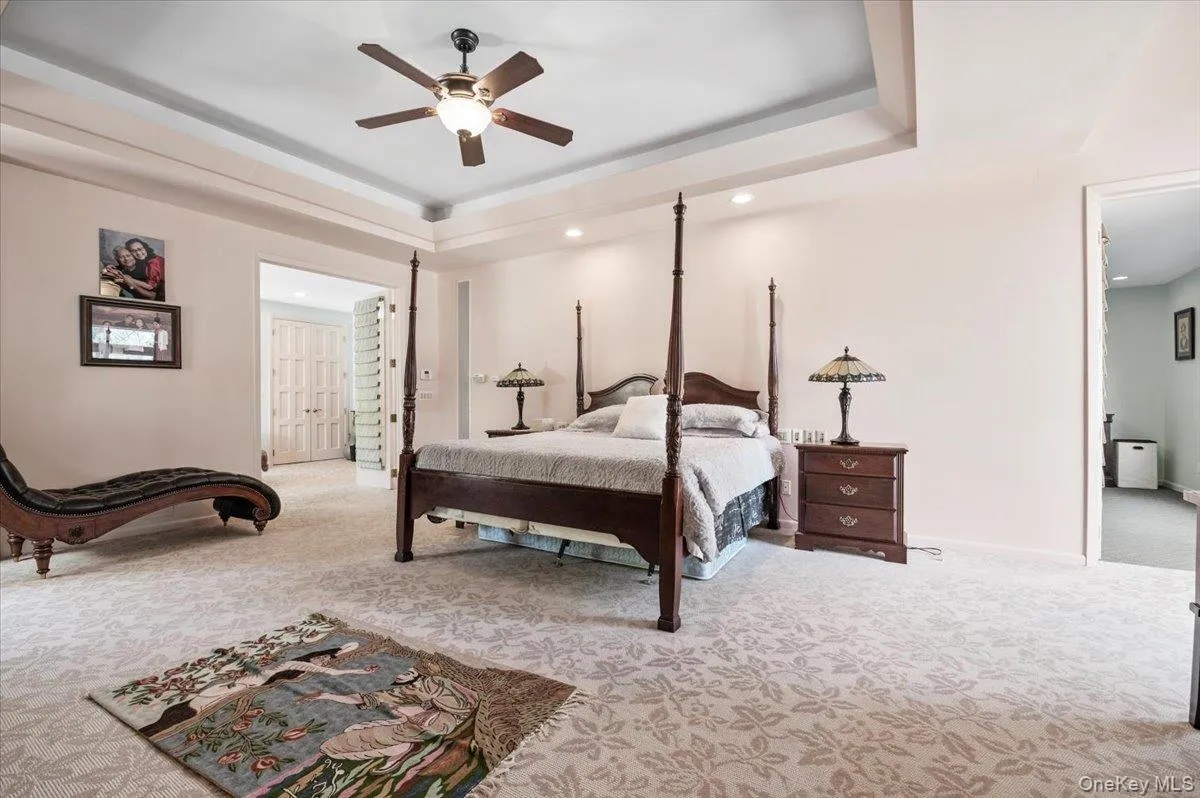Bedroom featuring light colored carpet, a raised ceiling, ceiling fan, and recessed lighting Bedroom featuring light colored carpet, a raised ceiling, ceiling fan, and recessed lighting