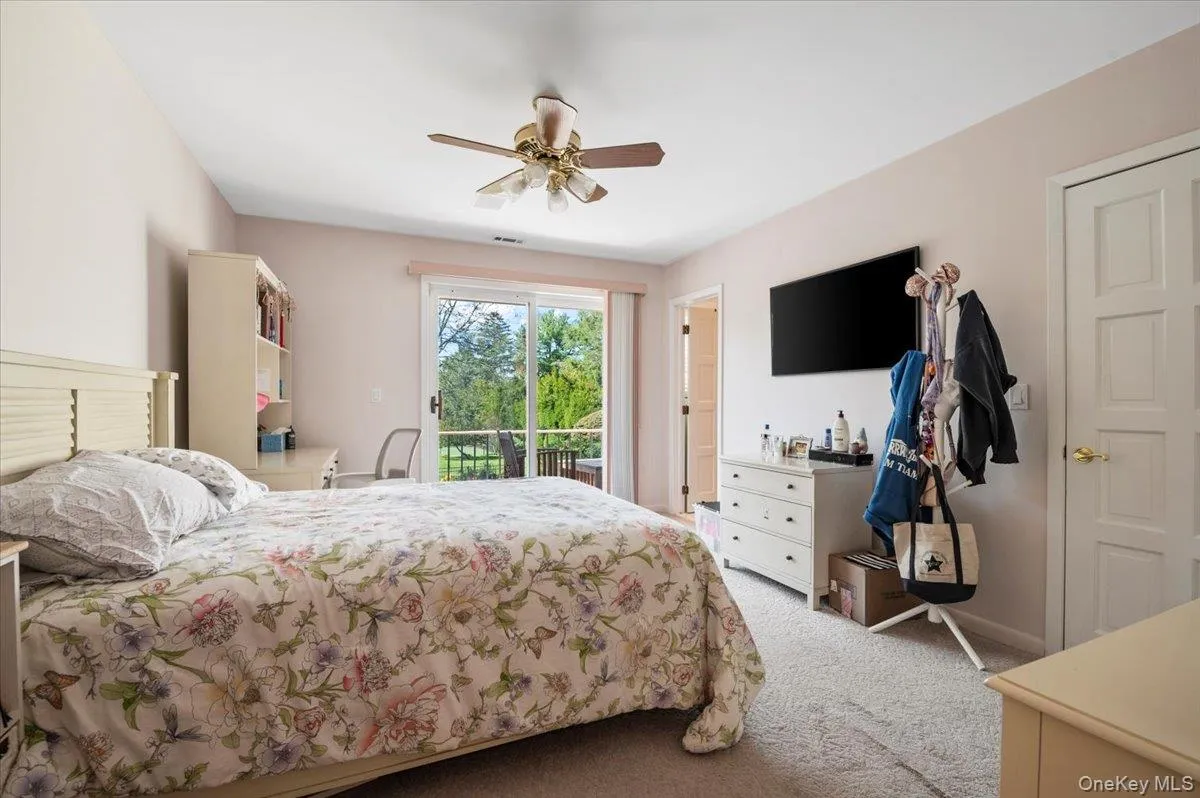 Bedroom with light colored carpet, a ceiling fan, and access to exterior Bedroom with light colored carpet, a ceiling fan, and access to exterior