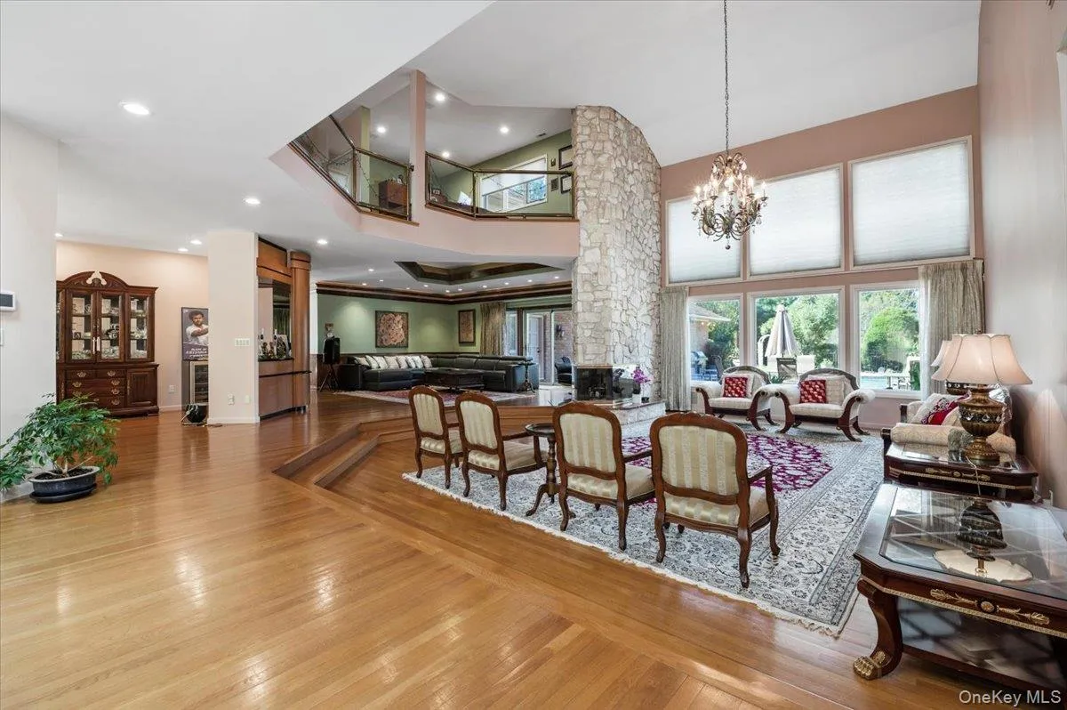 Dining room featuring light wood finished floors, a towering ceiling, recessed lighting, and a chandelier Dining room featuring light wood finished floors, a towering ceiling, recessed lighting, and a chandelier