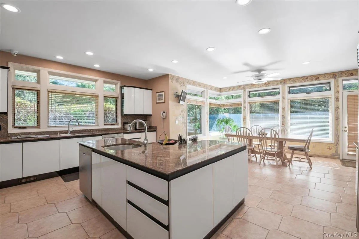 Kitchen with white cabinetry, a ceiling fan, plenty of natural light, and recessed lighting Kitchen with white cabinetry, a ceiling fan, plenty of natural light, and recessed lighting