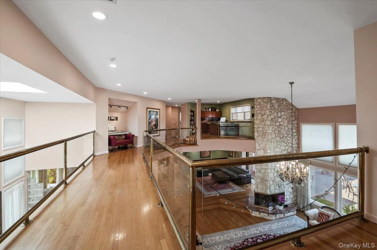 Hallway featuring an upstairs landing, light wood-style flooring, recessed lighting, and a chandelier Hallway featuring an upstairs landing, light wood-style flooring, recessed lighting, and a chandelier